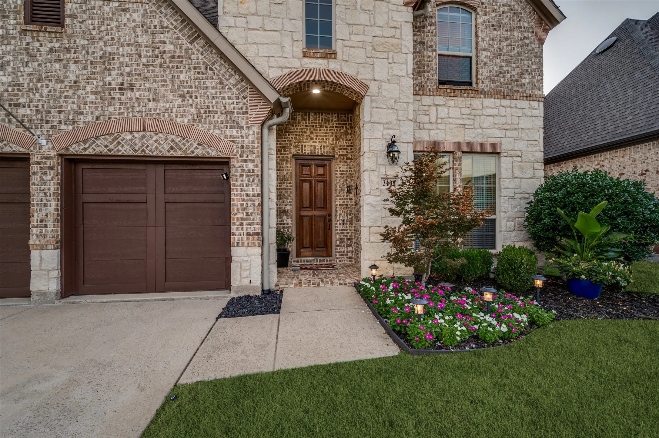 Charming curb appeal welcomes you home with a beautiful brick and stone elevation, inviting front porch, and lush professional landscaping that creates a warm first impression.