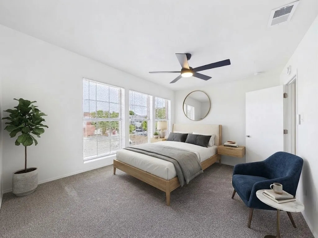 Bright room with three large windows, a built-in ceiling fan, and light-colored carpeting