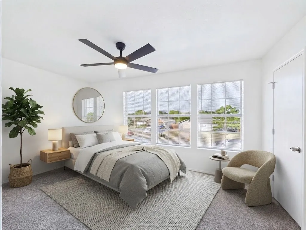 Recessed lighting, ceiling fan with integrated light, three large windows, white paneled door, and carpet flooring