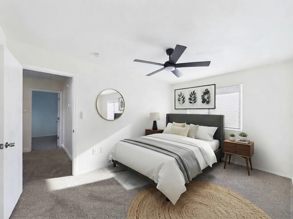 White interior walls, ceiling-mounted light fixture, window with blinds, and gray carpet flooring