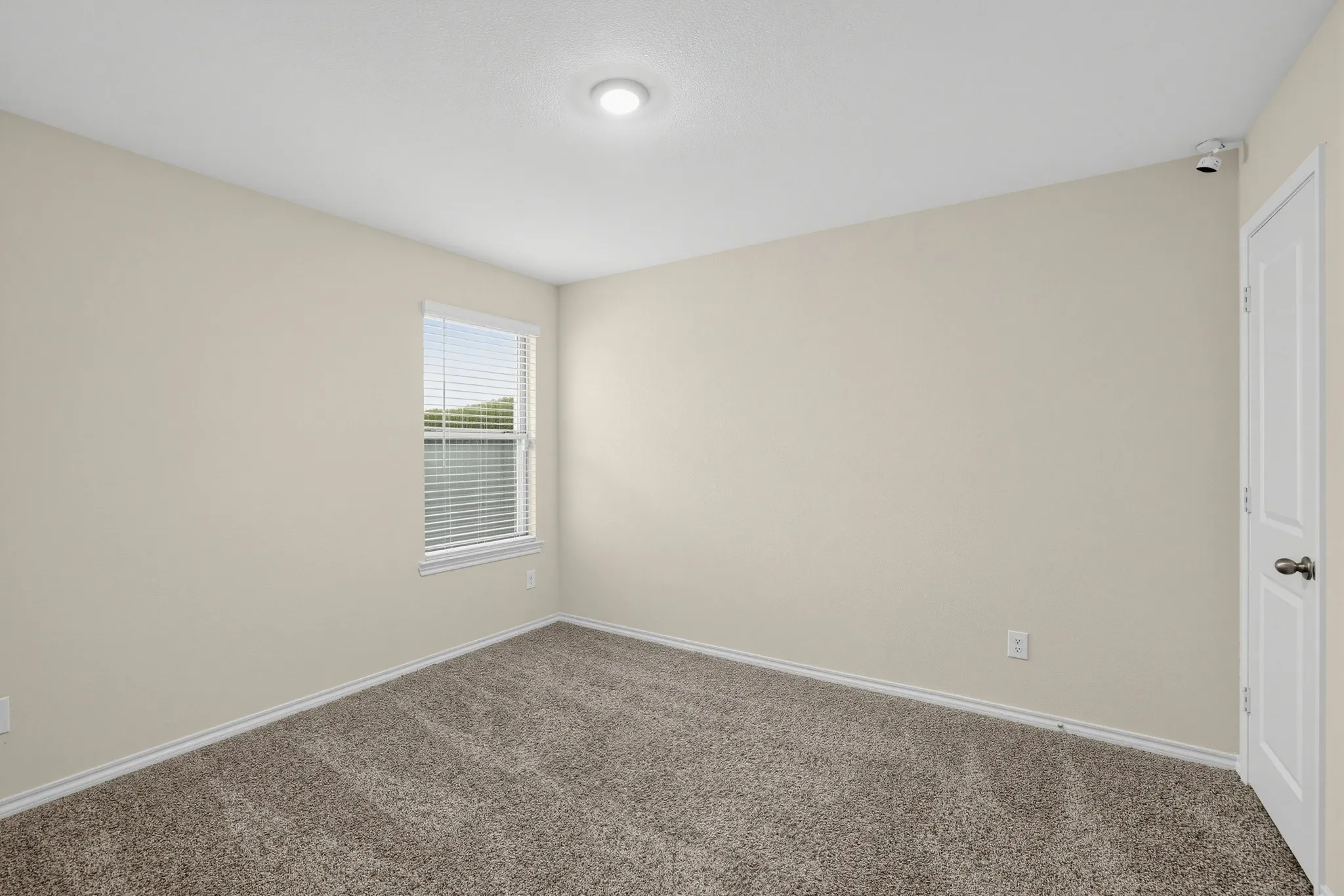 Neutral wall paint, recessed lighting, window with blinds, carpeted flooring, and a paneled door