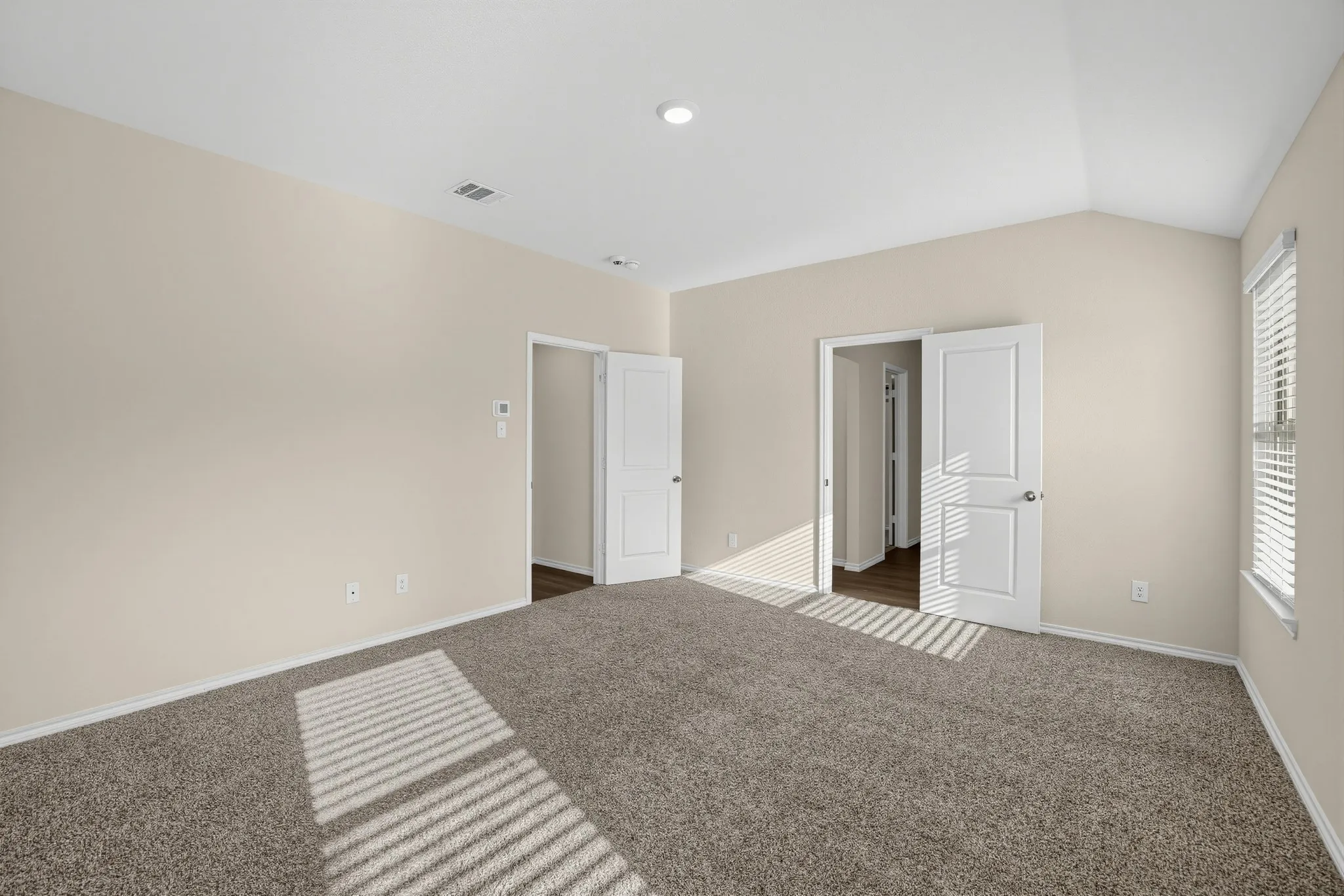 Vaulted ceiling, recessed lighting, neutral tone walls, carpeted flooring, and white window blinds
