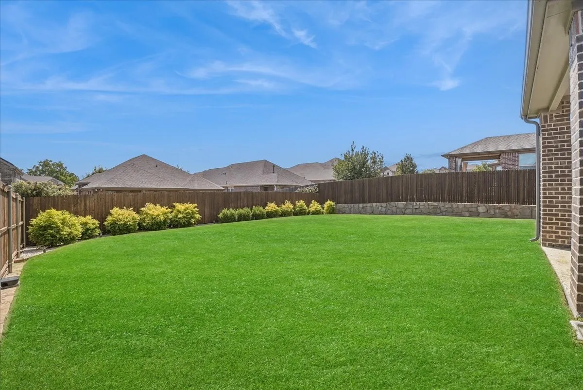 Spacious, beautifully maintained backyard with lush lawn and plenty of room for outdoor enjoyment.