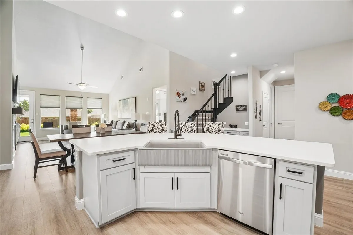 Oversized island with beautiful quartz countertops, farmhouse sink and abundant workspace.
