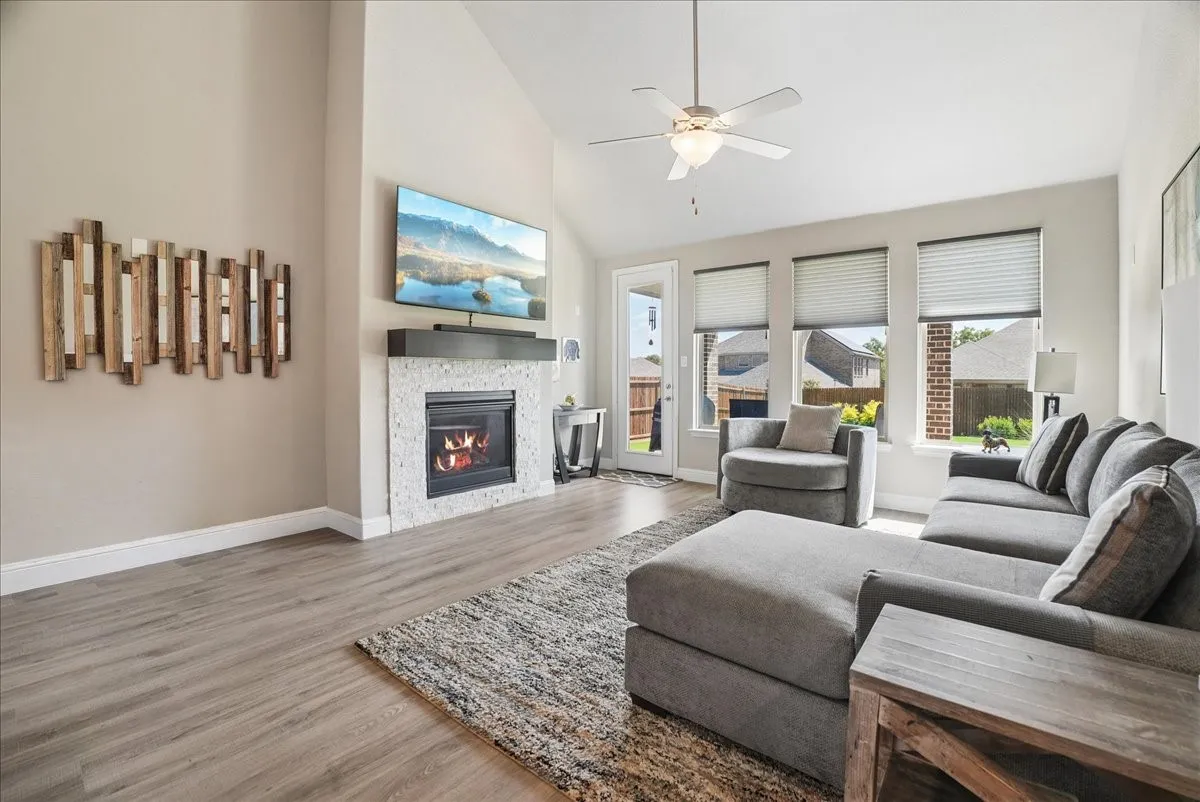 Bright, spacious living room with vaulted ceilings, fireplace and abundant natural light.