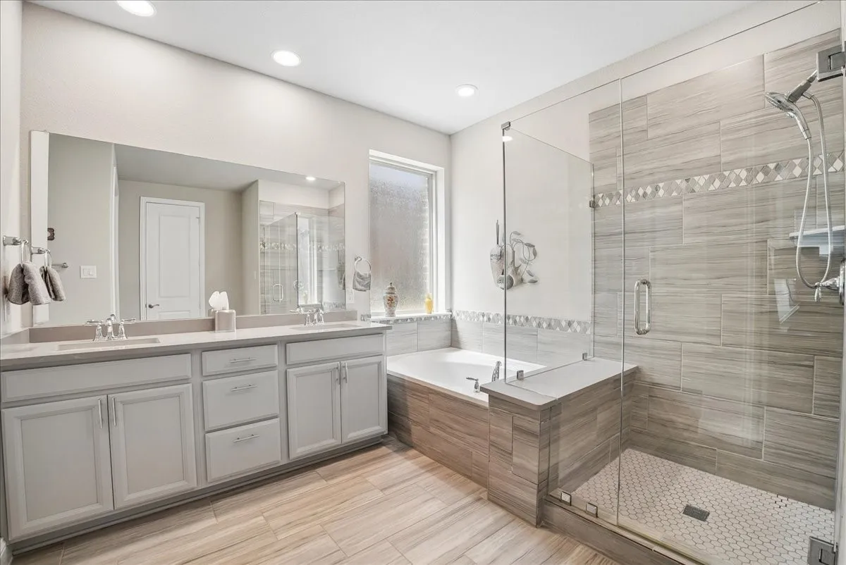 Primary bath with dual vanity, soaking tub and oversized walk-in shower.