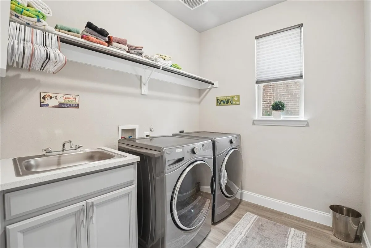 Convenient first-floor laundry room with utility sink, storage and natural light.