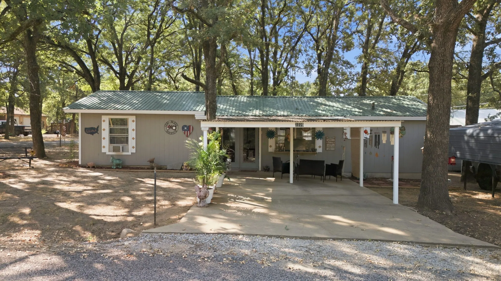 Gray siding exterior with a green corrugated metal roof
