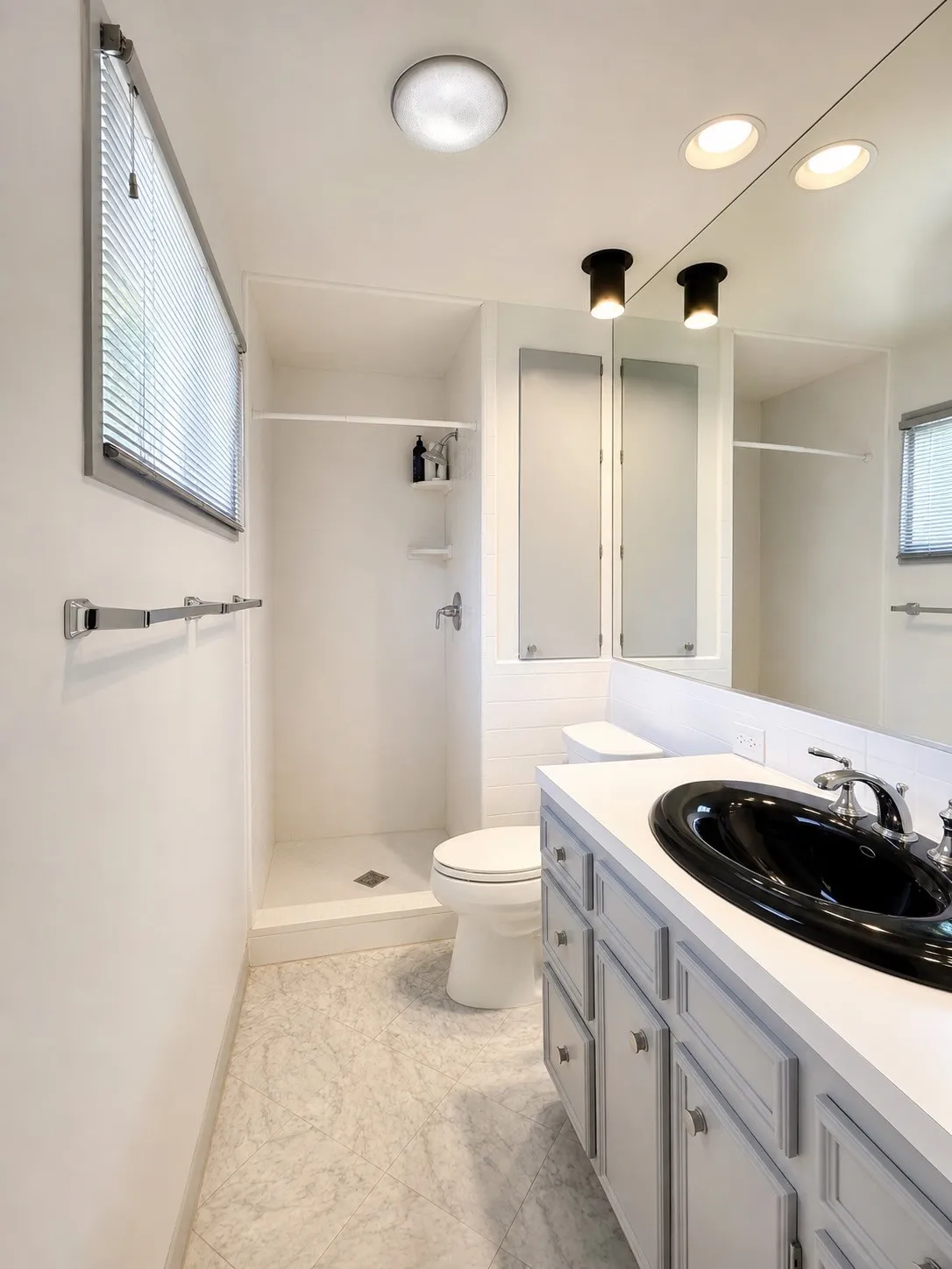 Vanity with a black oval sink, chrome faucet, and gray cabinetry
