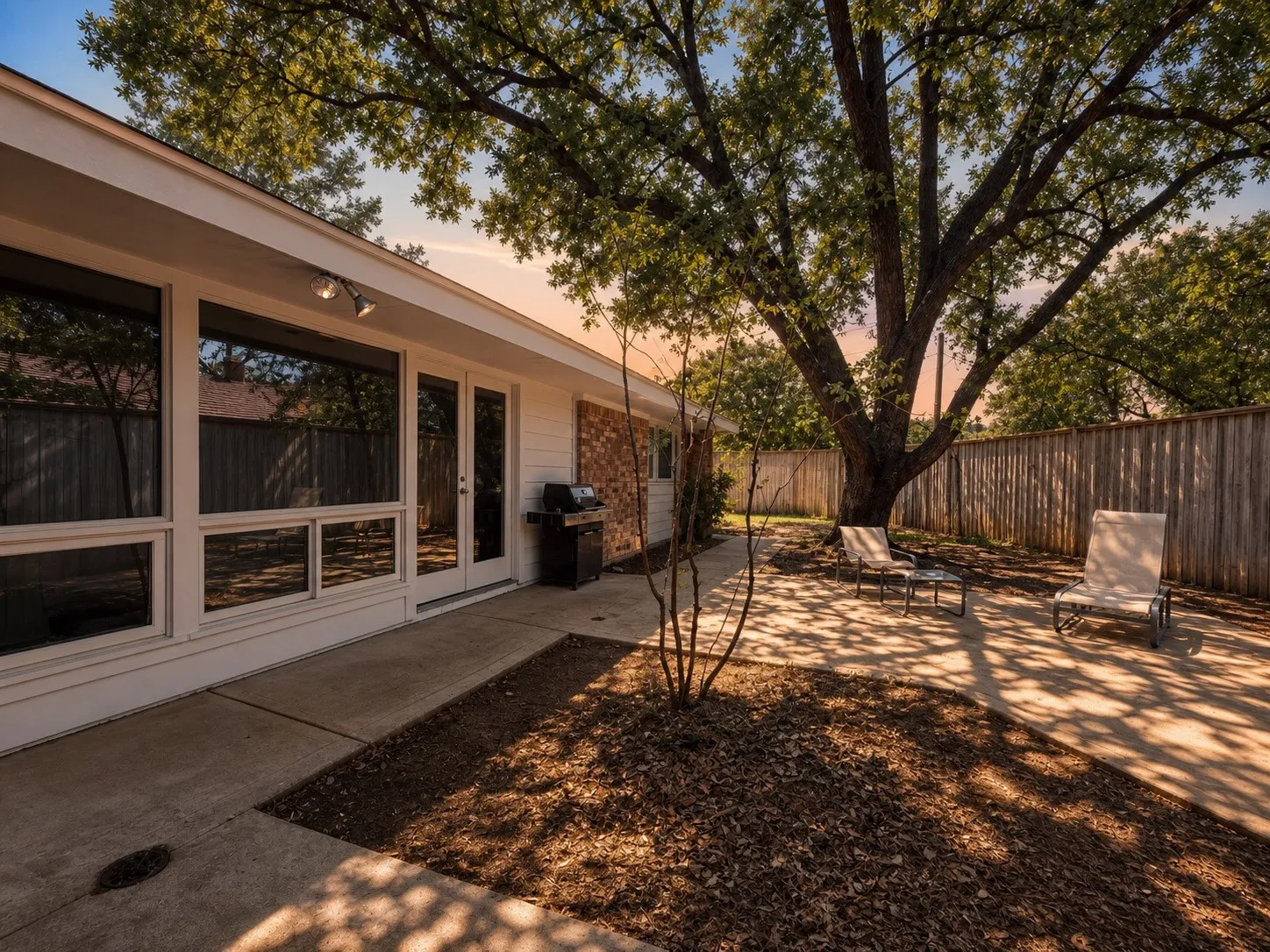 Expansive concrete patio with direct access to interior spaces through French doors