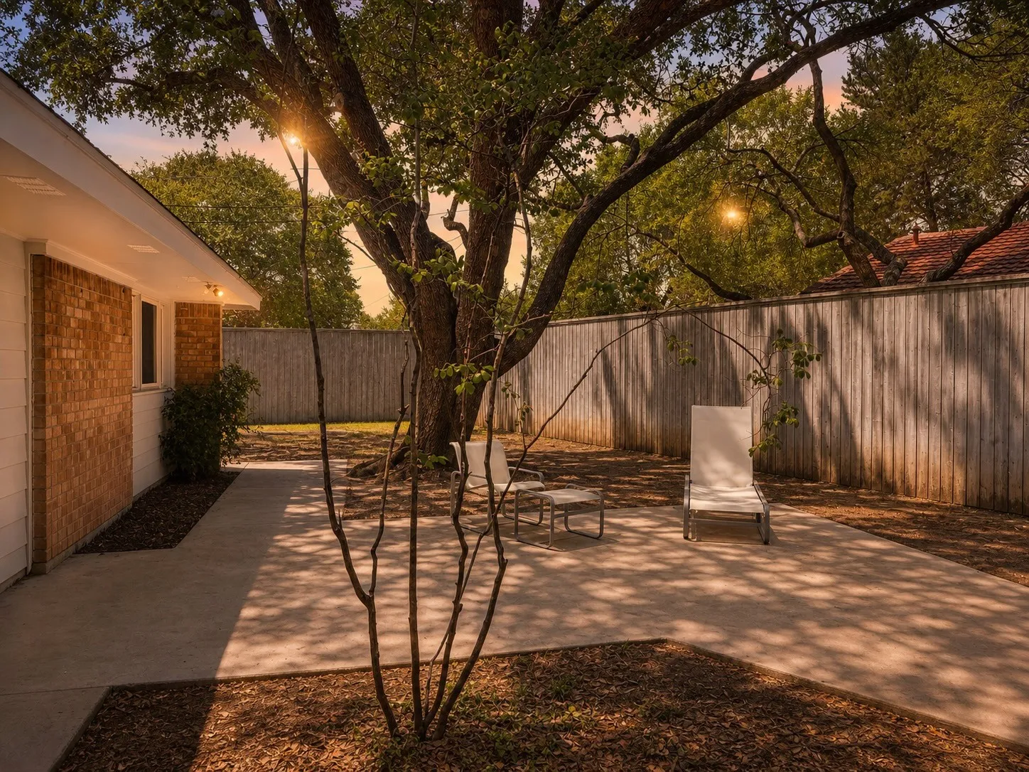 Exterior featuring a brick facade, white siding, and built-in lighting