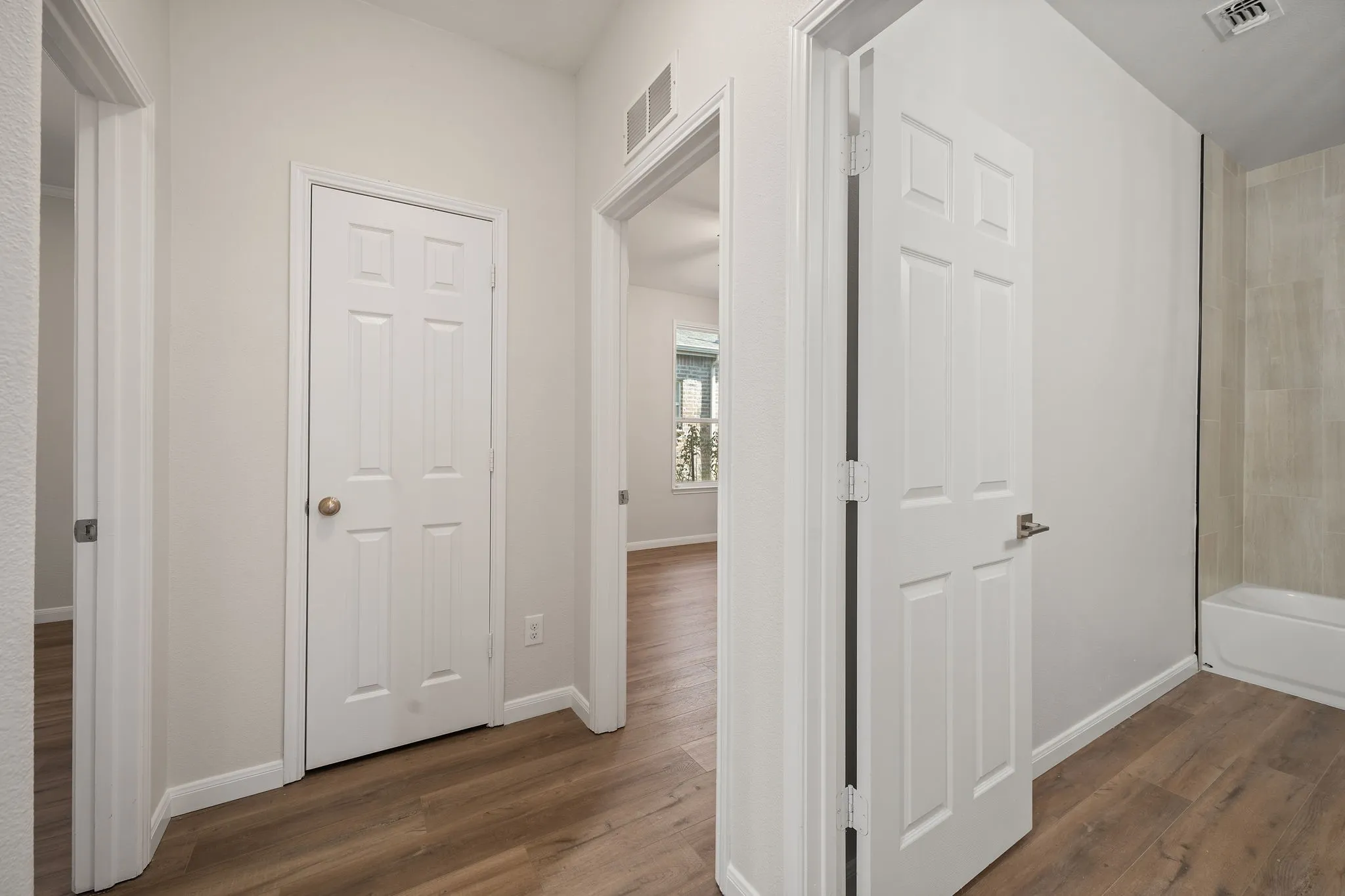 Wood-finish flooring throughout, white interior doors, and light-toned wall finishes