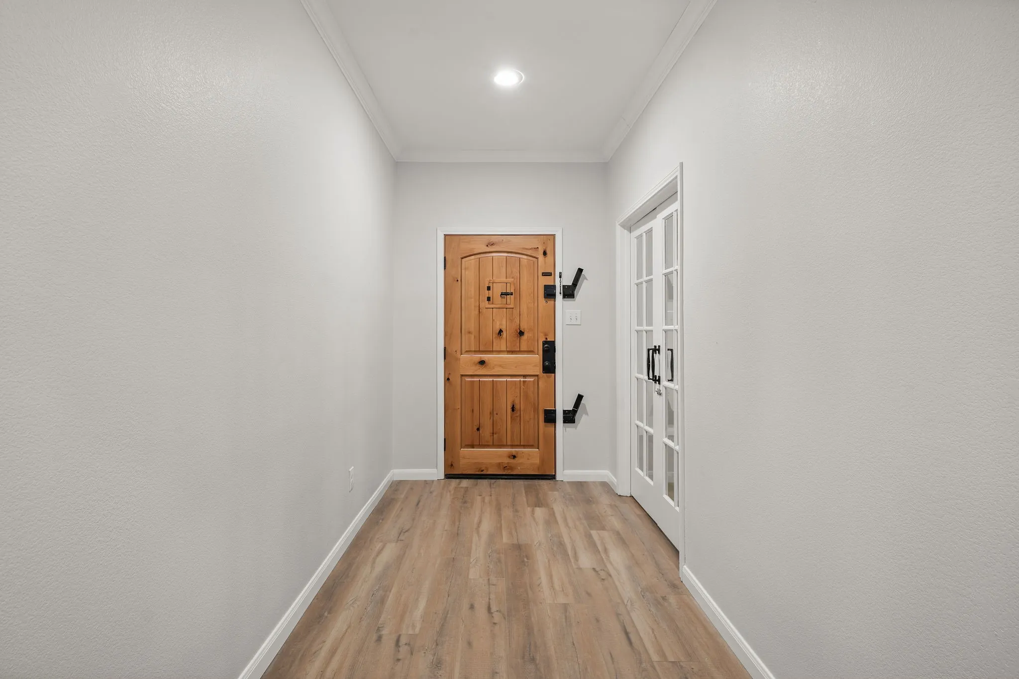 Wood-finish flooring, recessed lighting, and crown molding