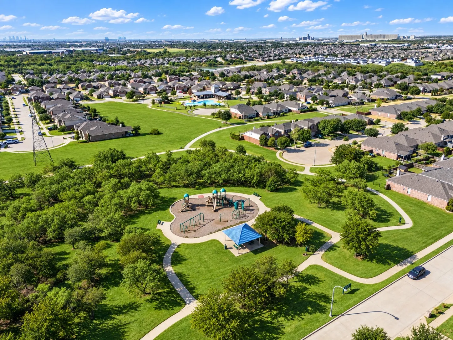 Community park featuring playground equipment, a covered picnic area, and walking paths