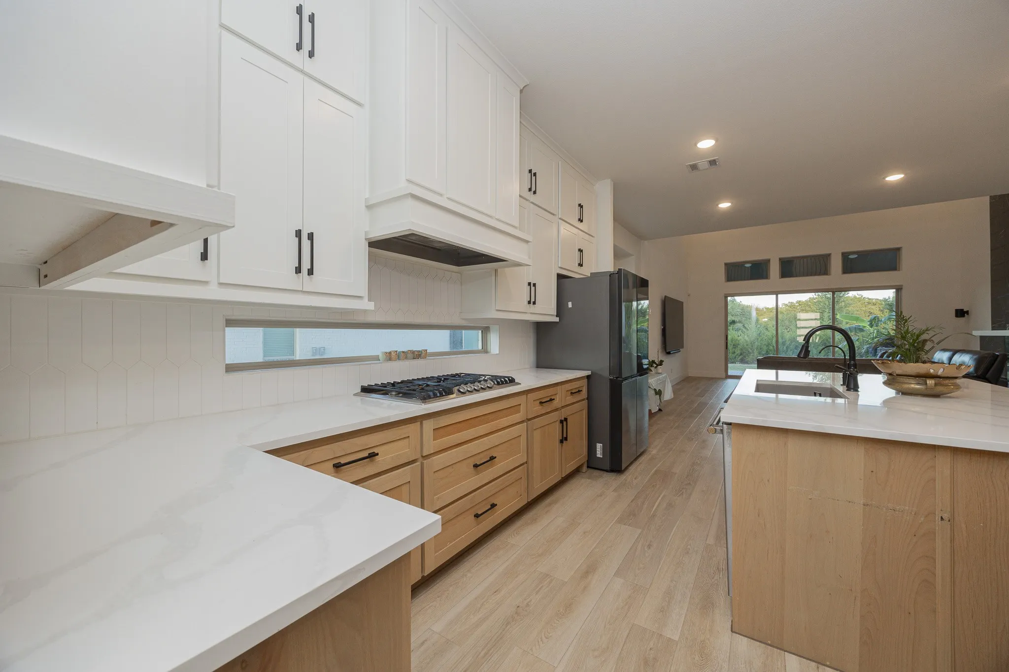 Kitchen featuring white upper cabinetry, wood-finish lower cabinetry, white countertops, and a gas range