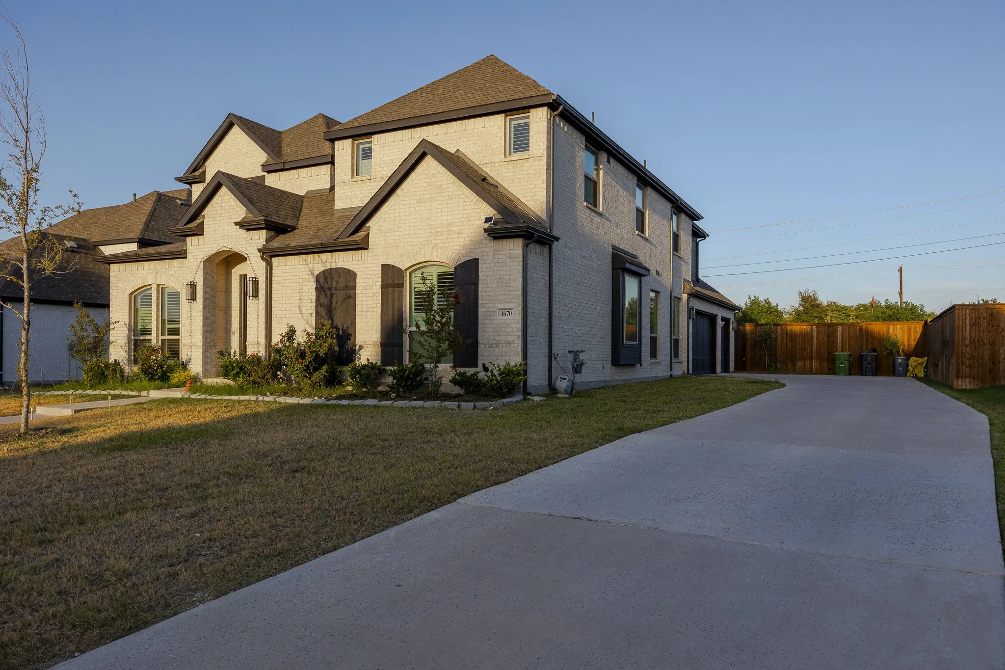Brick exterior with dark shutters, arched entry, and a multi-level roofline