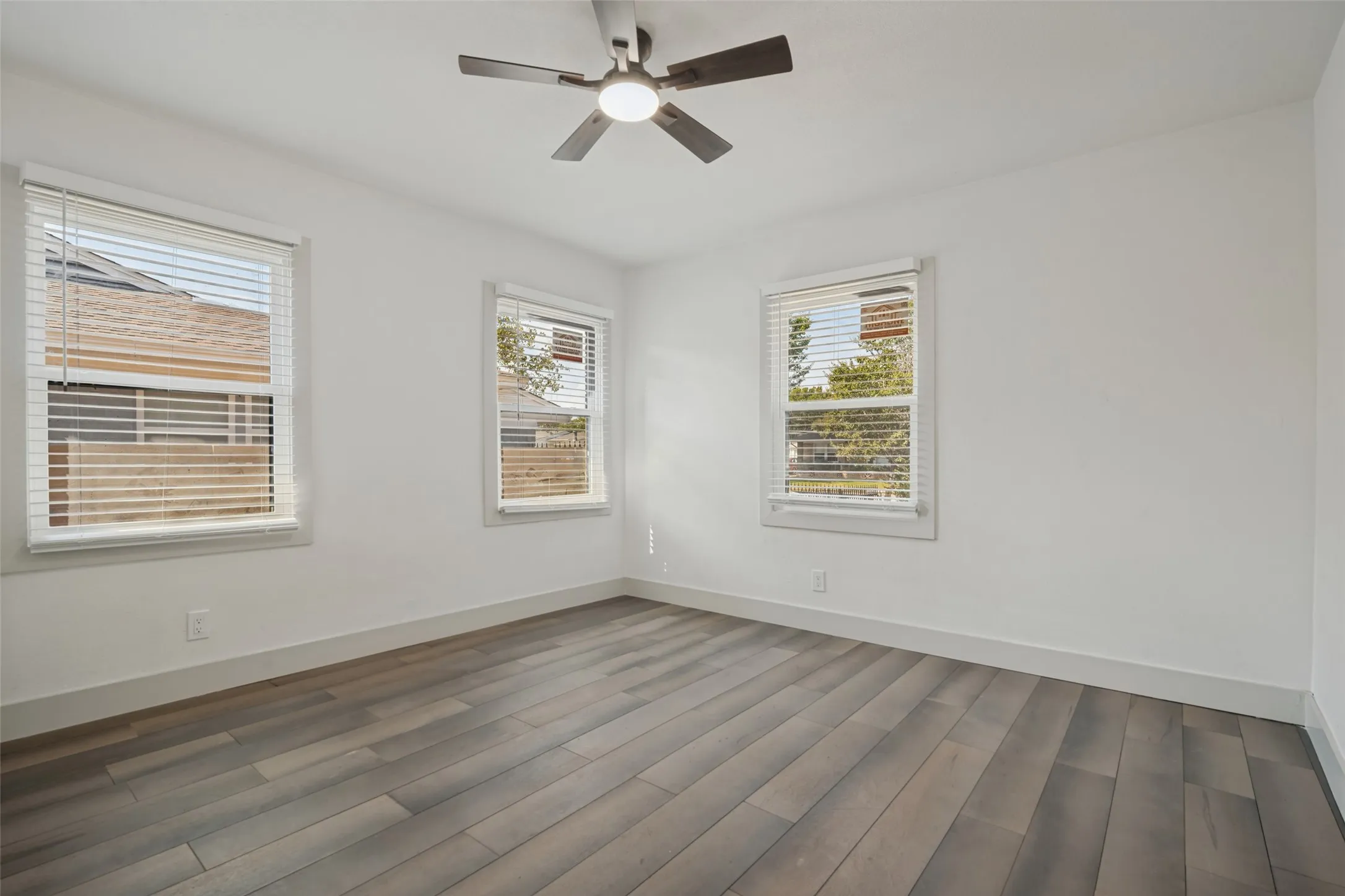 White walls, wood-finish flooring, and white trim throughout
