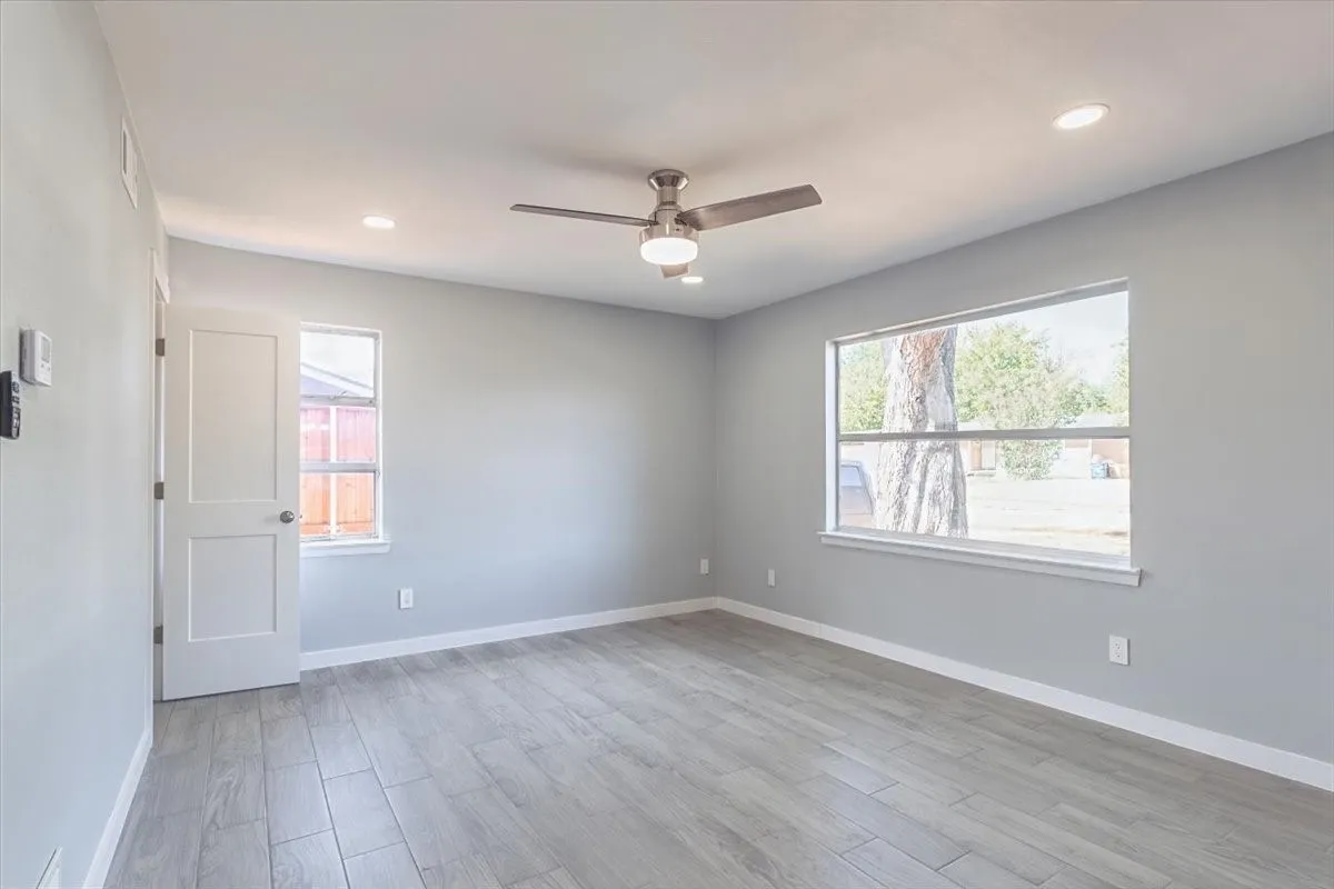 Recessed lighting, ceiling fan with light kit.,Tile flooring, white trim, and a window with white casing