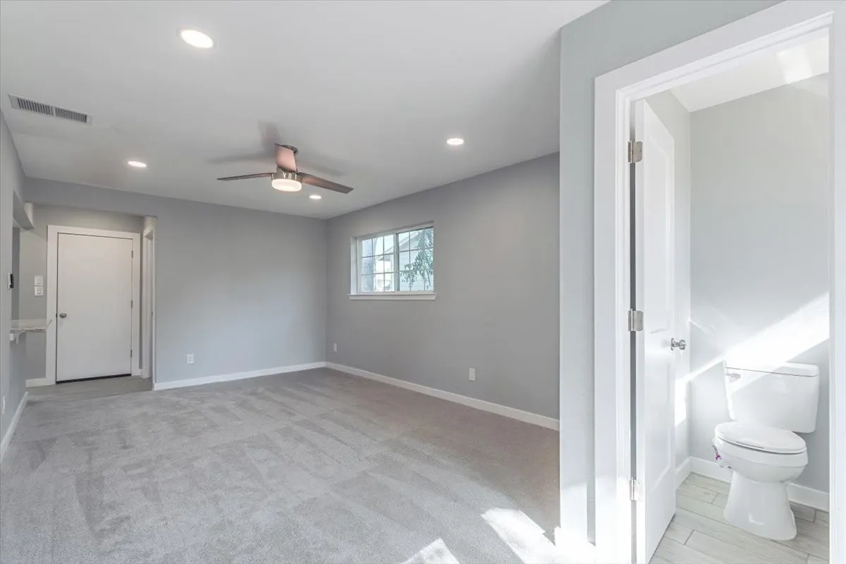 Recessed lighting, ceiling fan with integrated light, grey tile flooring, and a window with exterior visibility