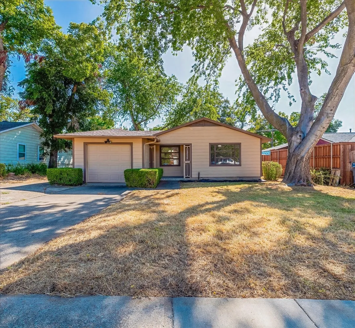 Single-story residence featuring a front-facing attached garage, exterior siding, and a paved driveway