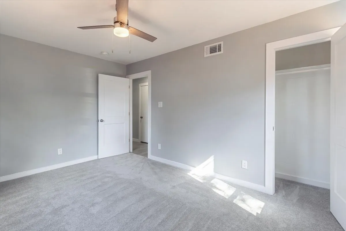 Recessed lighting, ceiling fan with integrated light, light gray wall paint, and gray carpet flooring