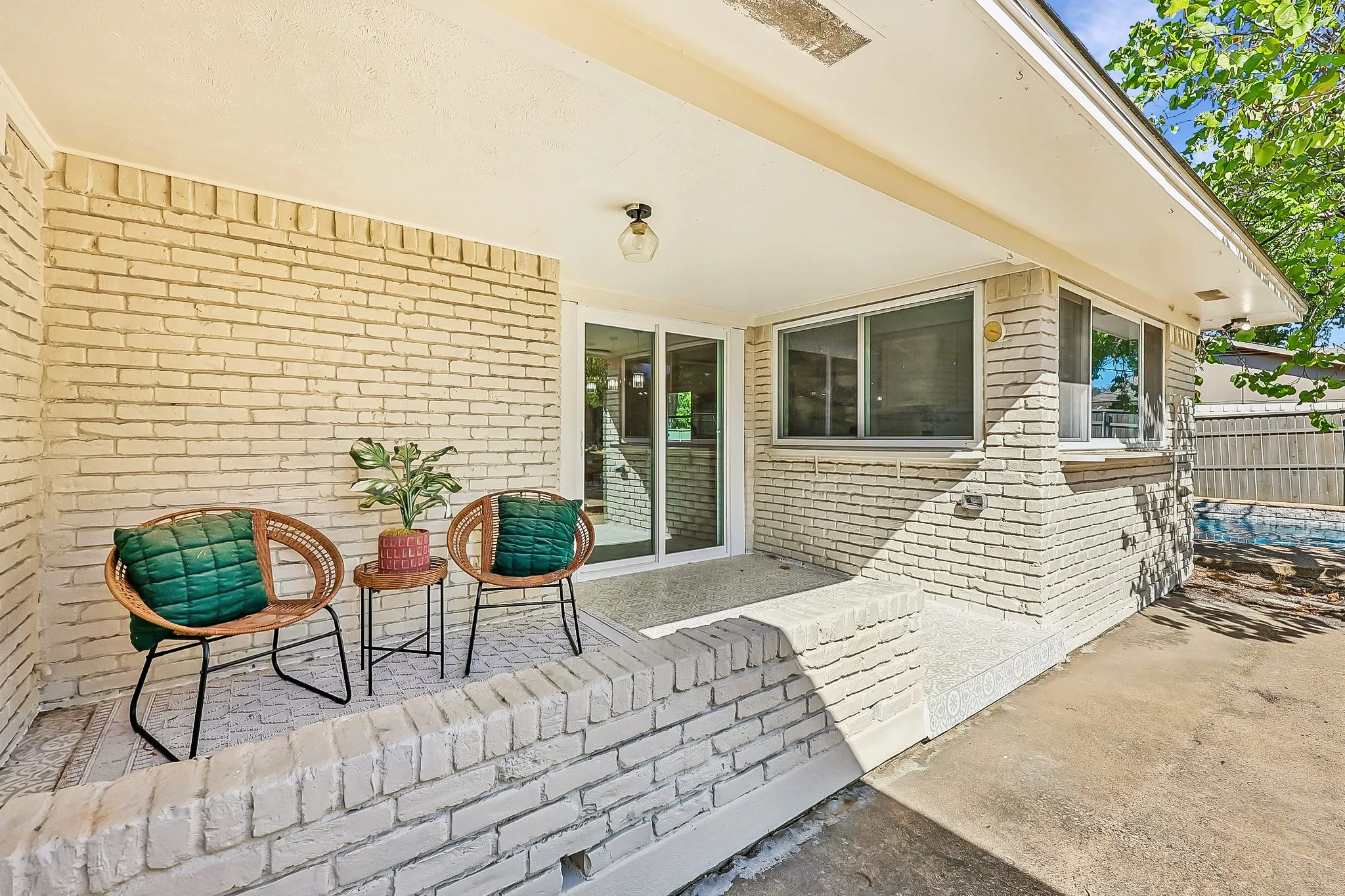 Covered patio with brick exterior and sliding glass door access