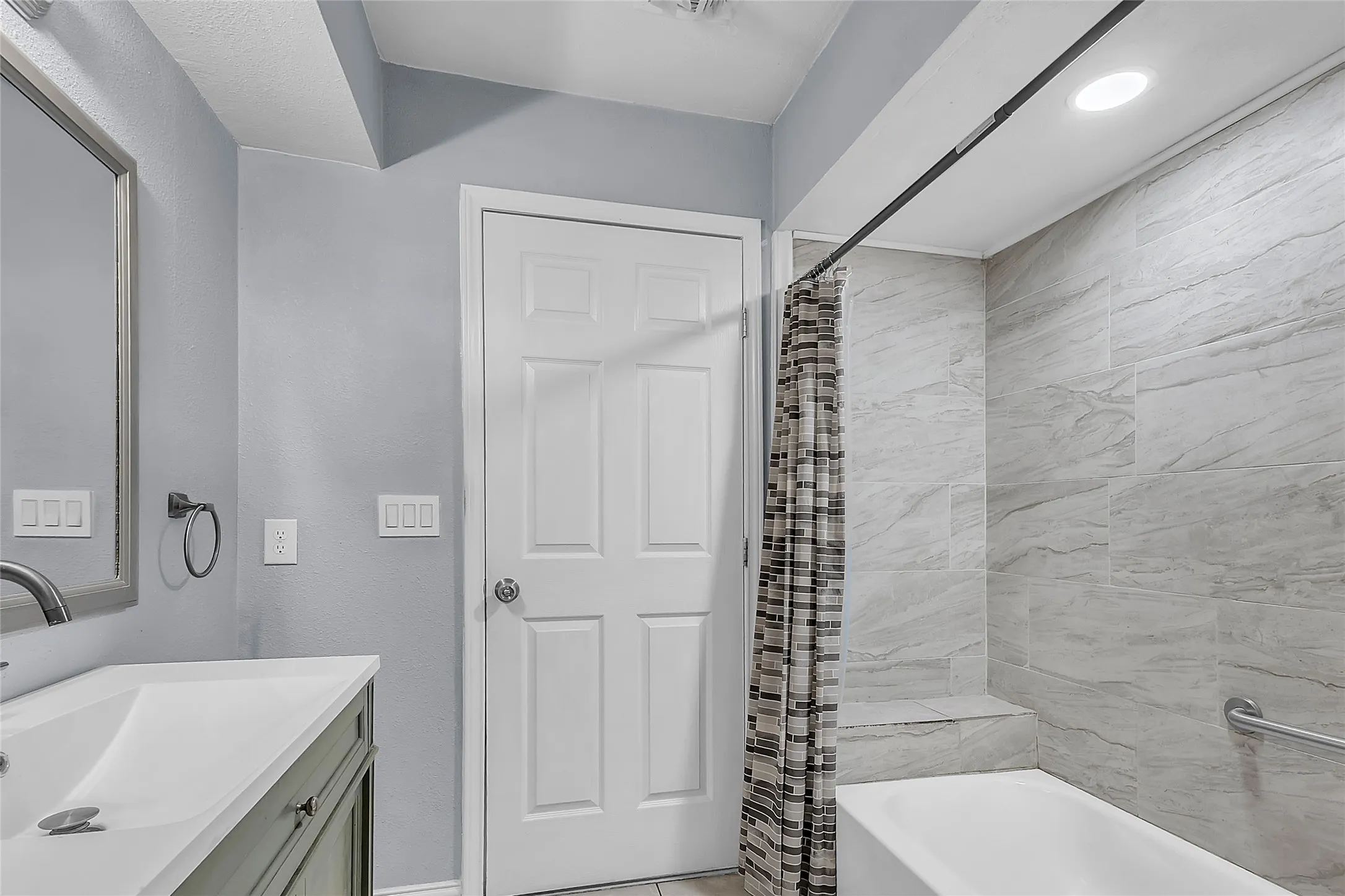 Bedroom with light-colored walls, laminate flooring, ceiling fan, and natural light from a window with blinds. Double closet doors enhance storage options.