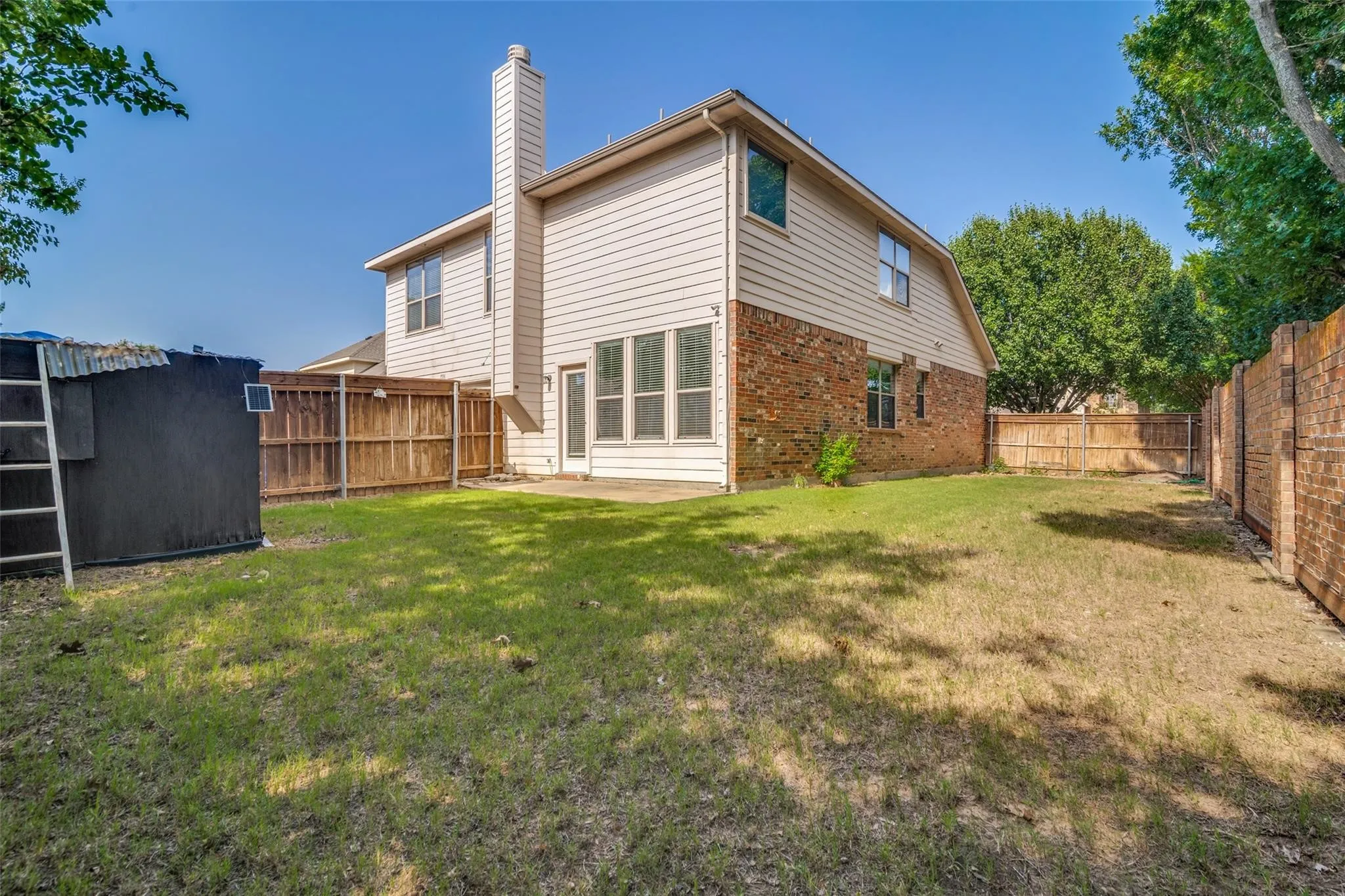 Expansive grassy yard with a concrete patio