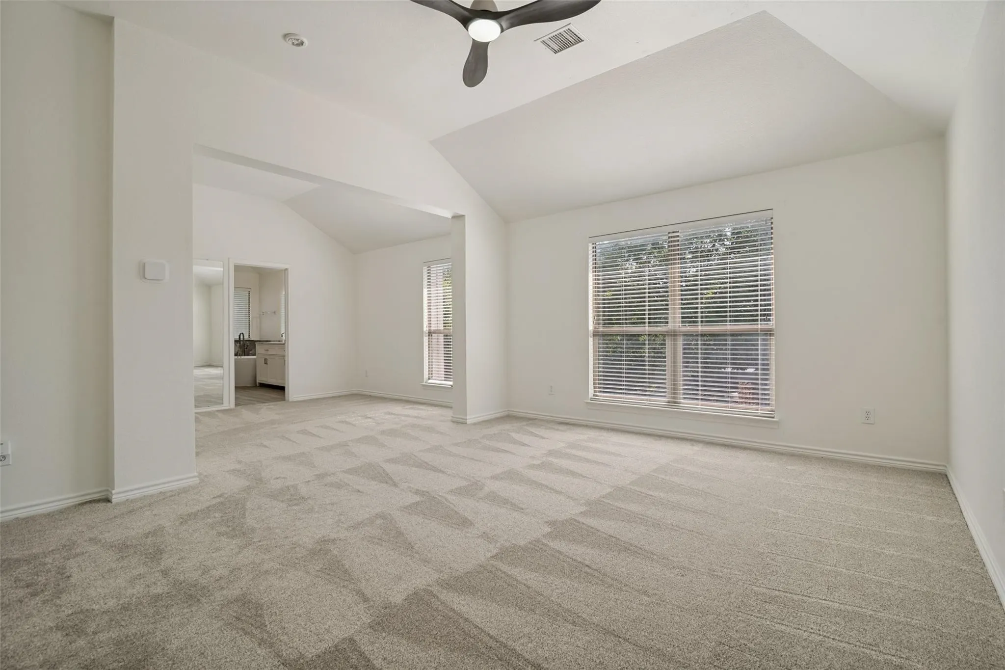 Vaulted ceiling with a contemporary ceiling fan, recessed lighting, and a large window with horizontal blinds