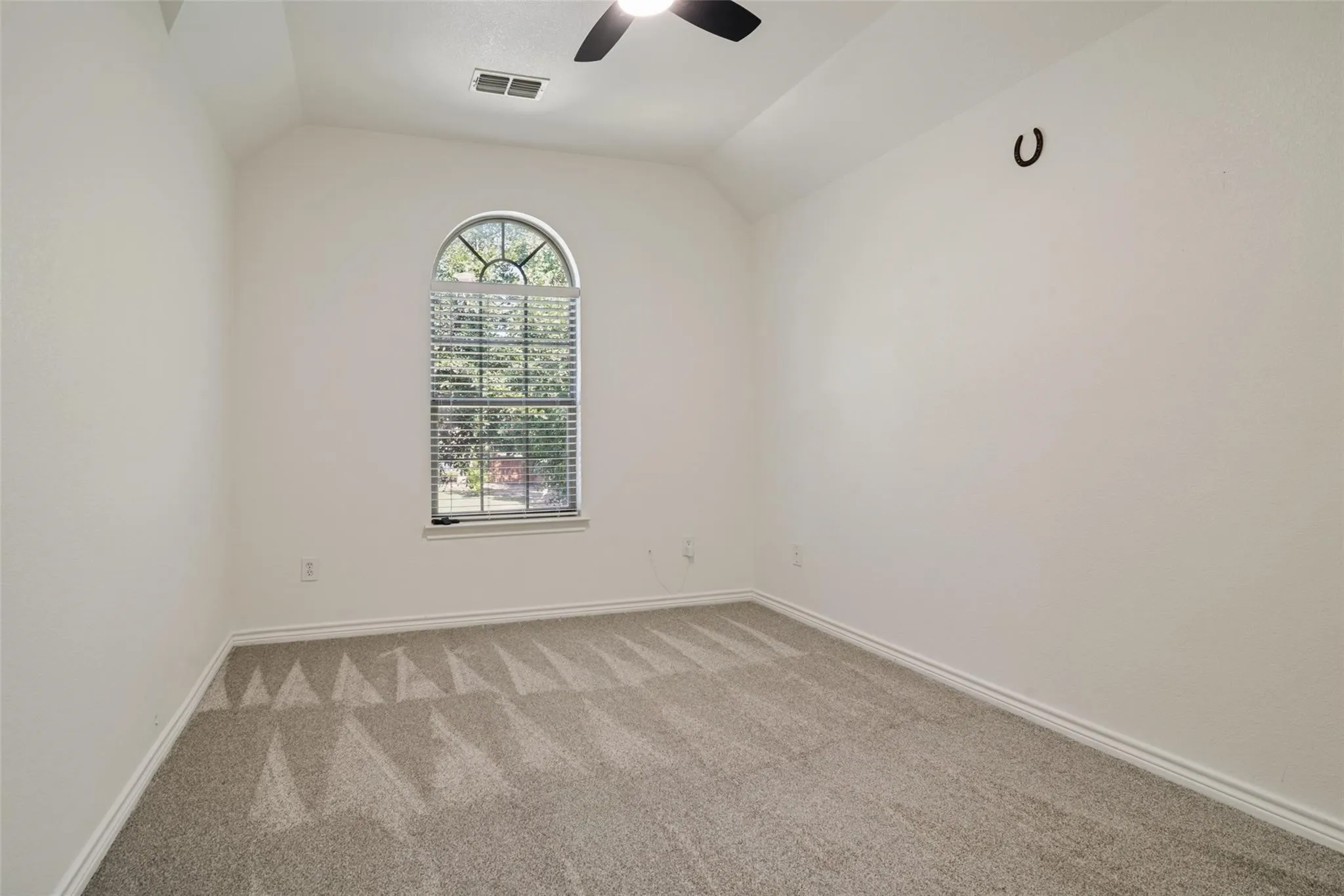 Arched window with blinds, vaulted ceiling, and ceiling fan