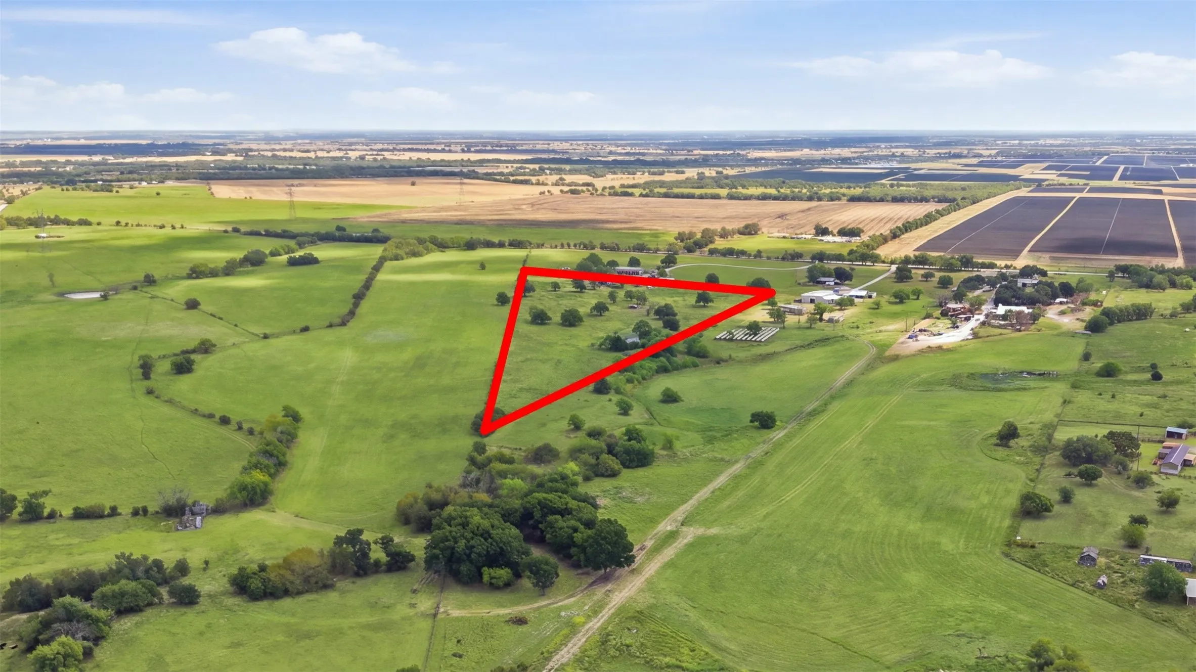 Expansive green acreage featuring scattered mature trees and open fields