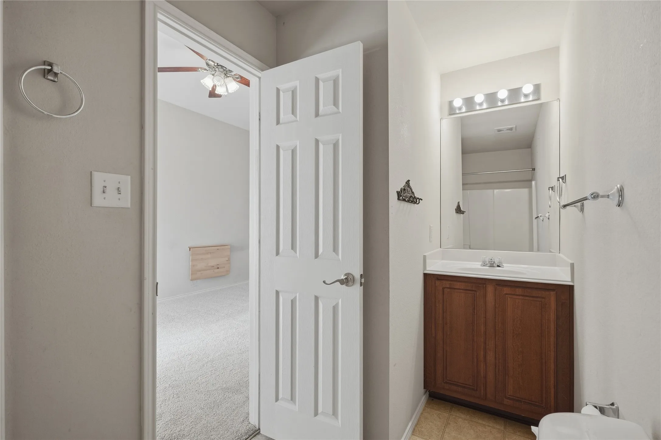 Wood-finish vanity with an integrated sink and reflective mirror