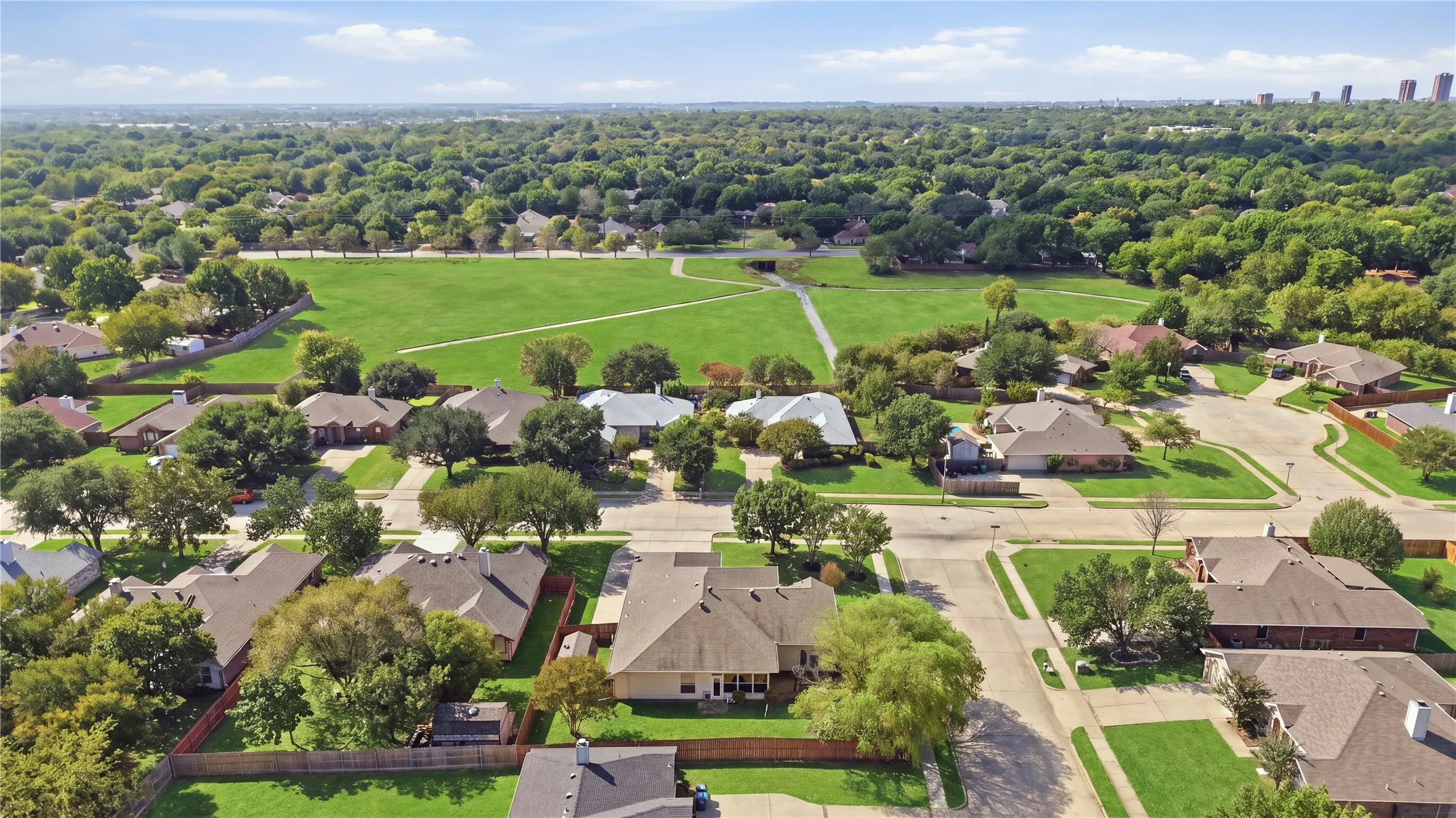 Expansive green space bordered by mature trees