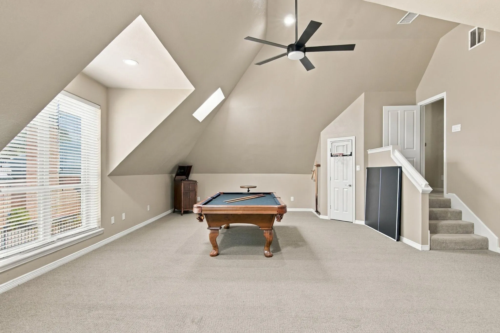 Spacious recreation room is perfect for the kids or entertaining.  Features sloped ceilings, recessed lighting, and a ceiling fan.  Full size pool table conveys.