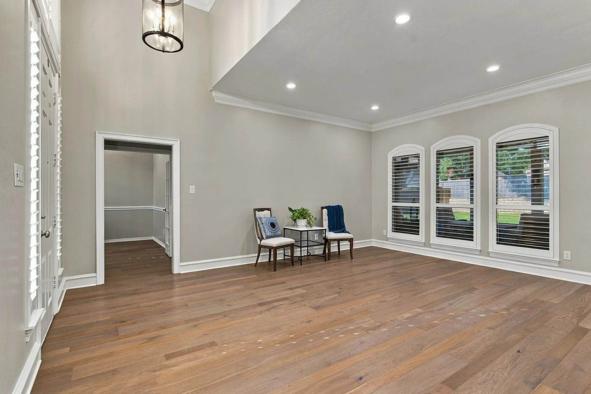Expansive living room featuring wood-finish flooring, recessed lighting, and crown molding