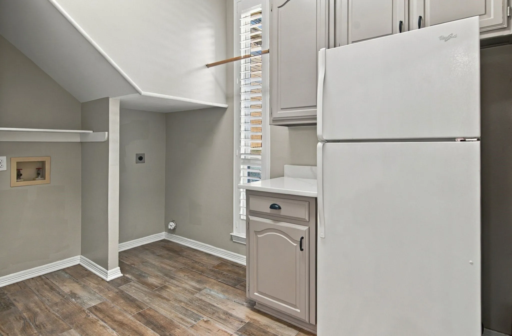 Large laundry with built-in cabinetry, room for full size washer/dryer, and refrigerator.