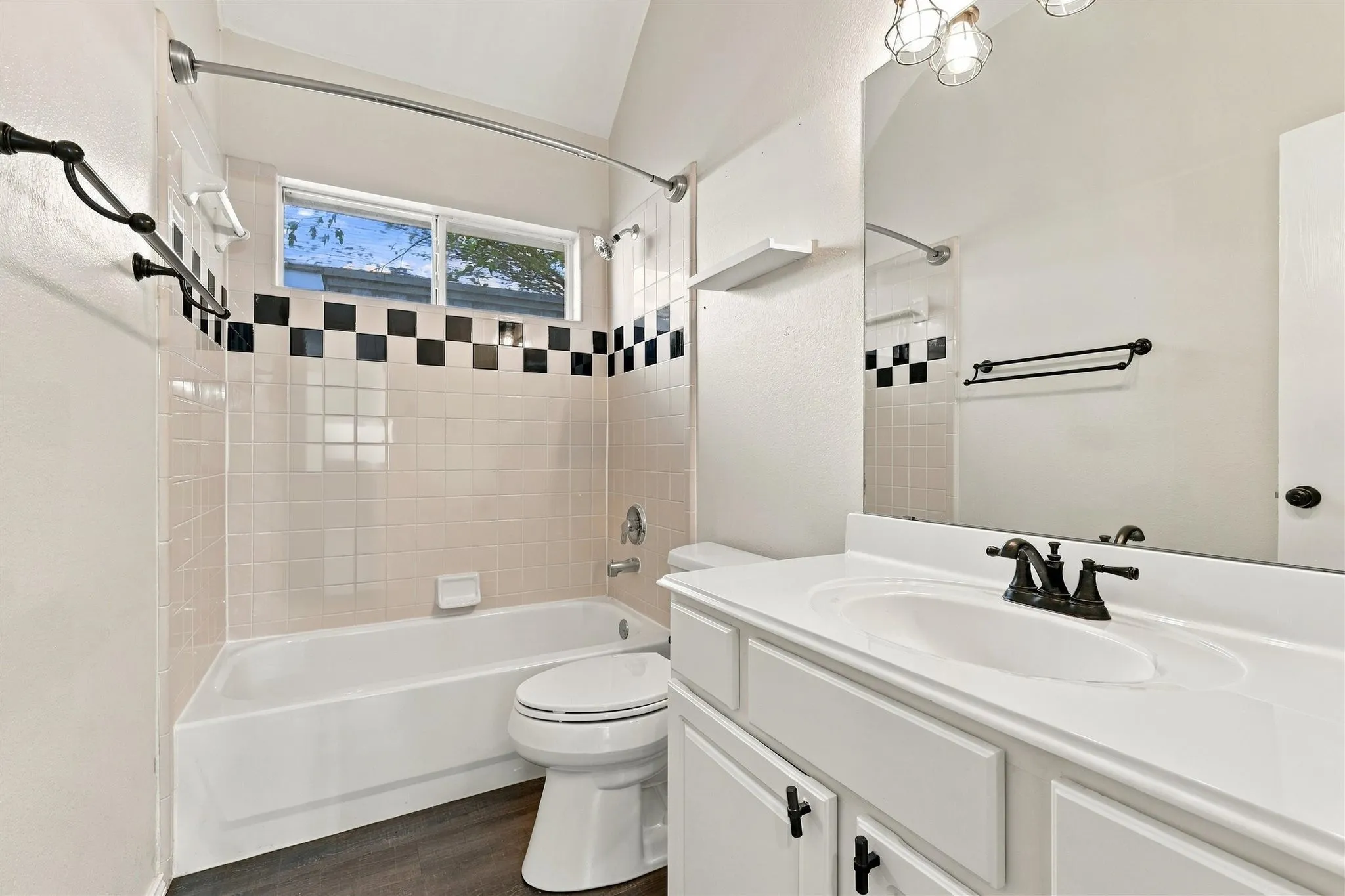 White vanity with an integrated sink and dark bronze fixtures