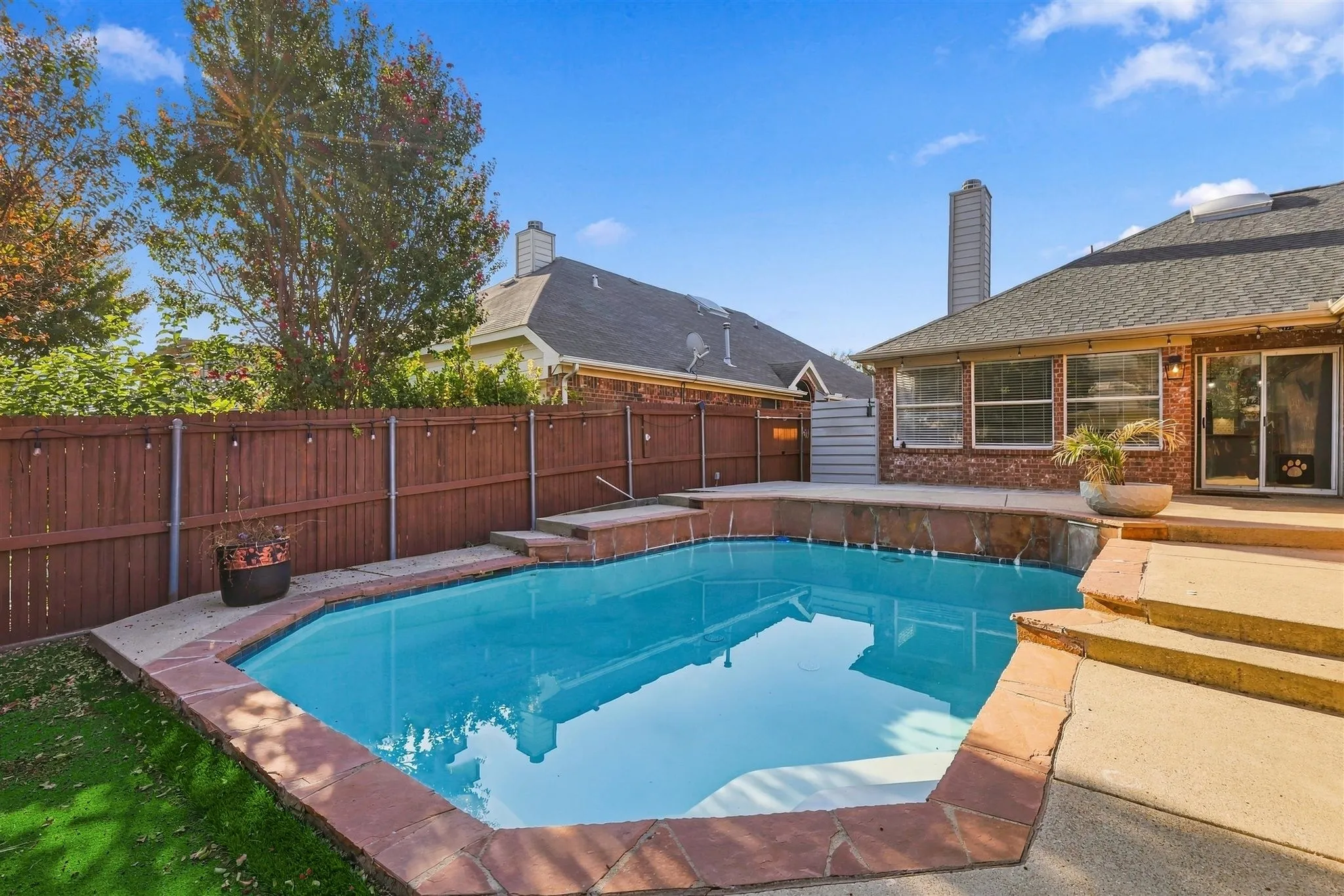 Backyard pool with a stone coping and a raised spa area