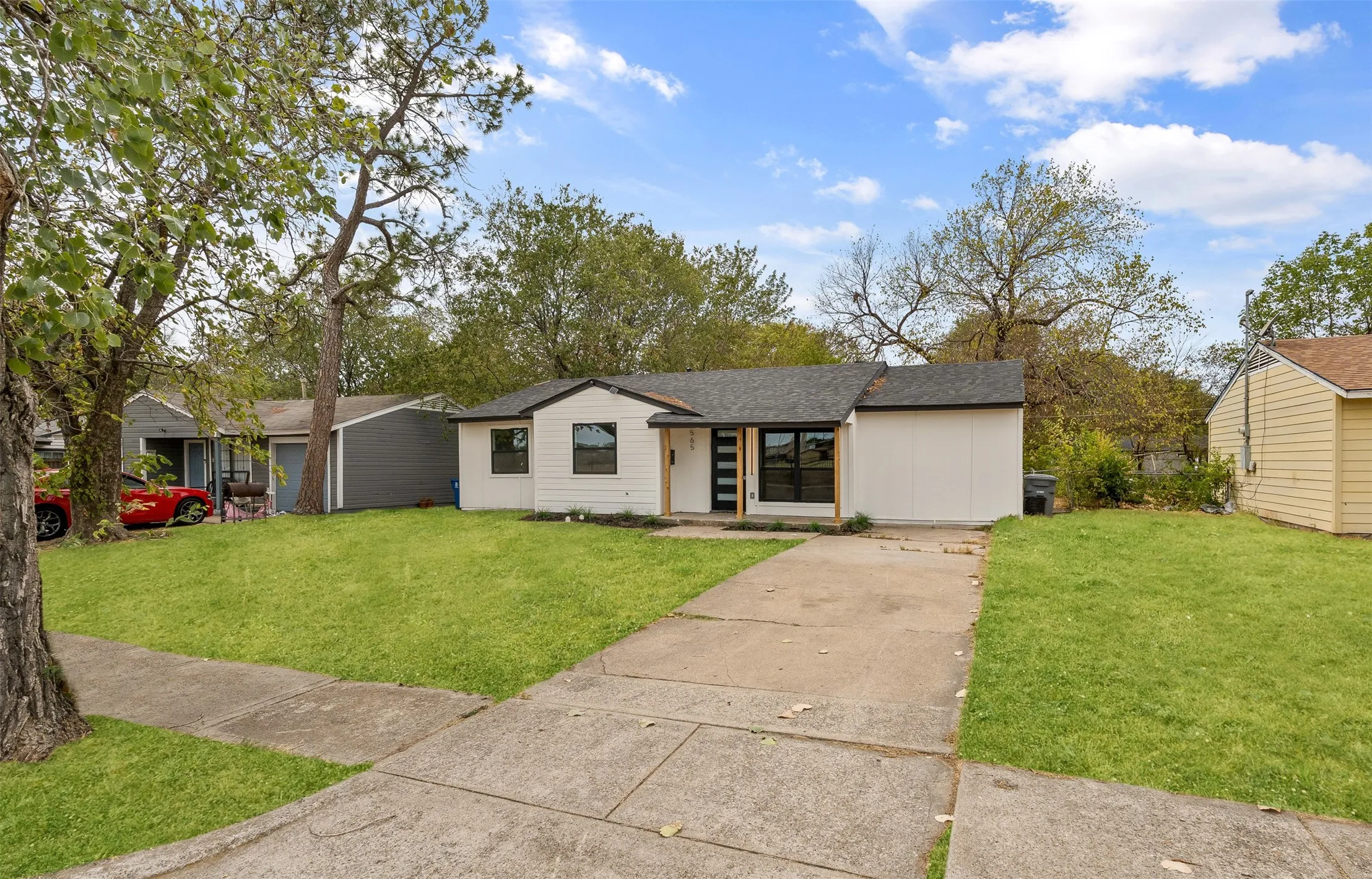 Single-story residence featuring a white exterior, black trim, and a concrete driveway