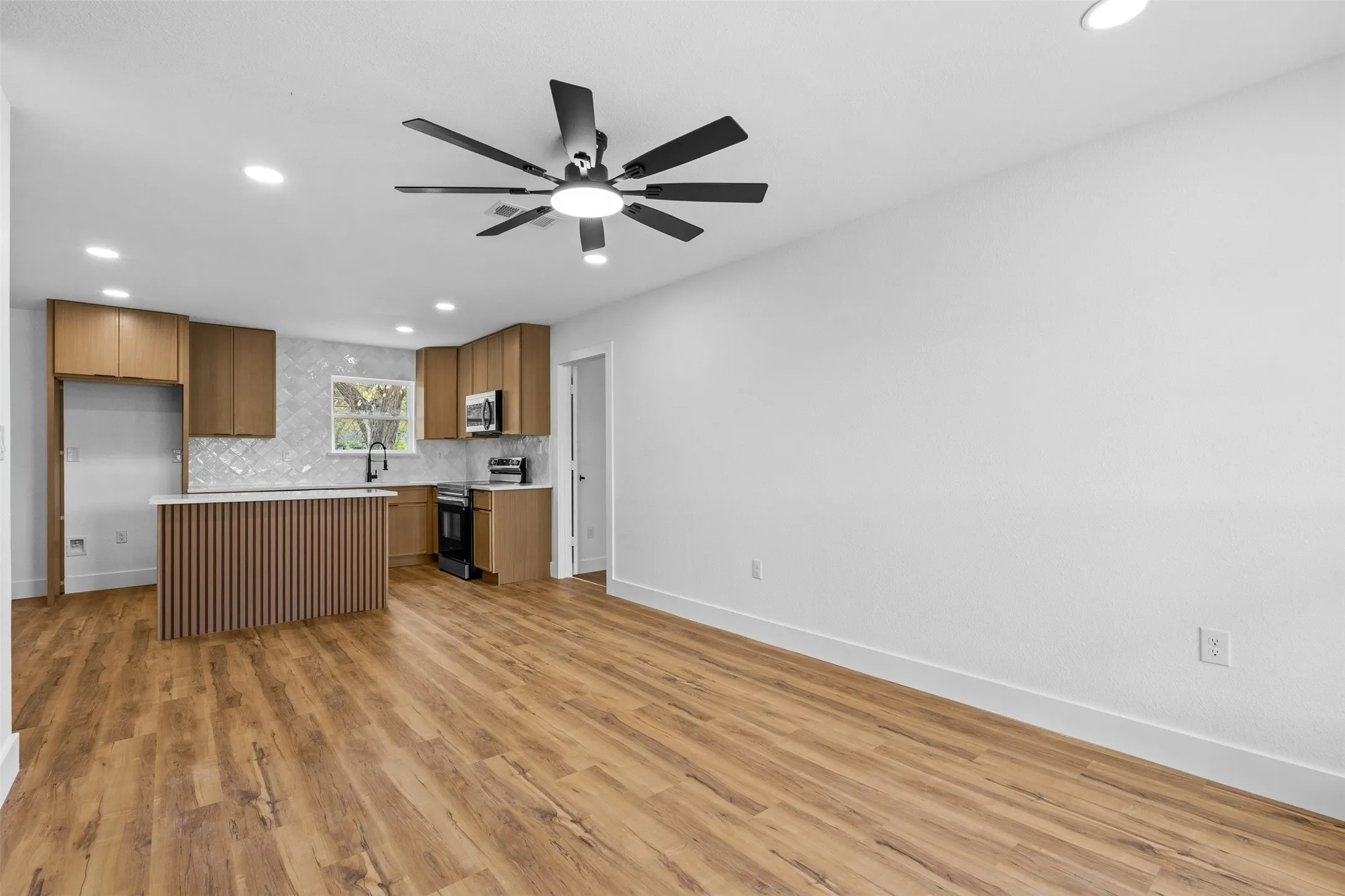 Wood-finish flooring throughout, recessed lighting, and a modern ceiling fan