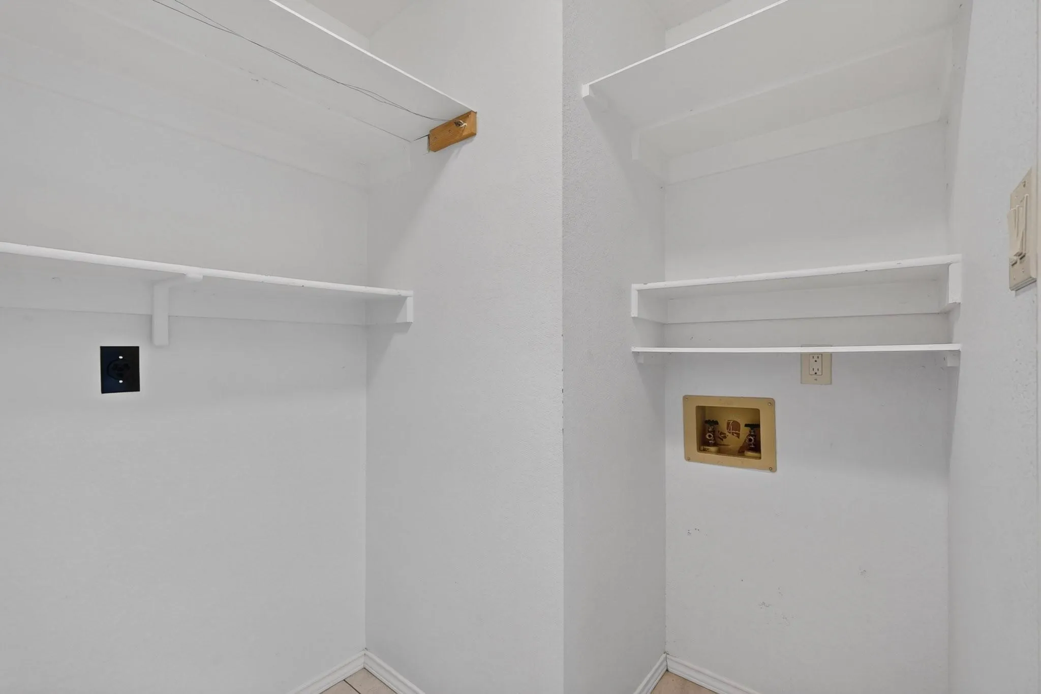 Laundry area featuring multiple storage shelves and utility hookups