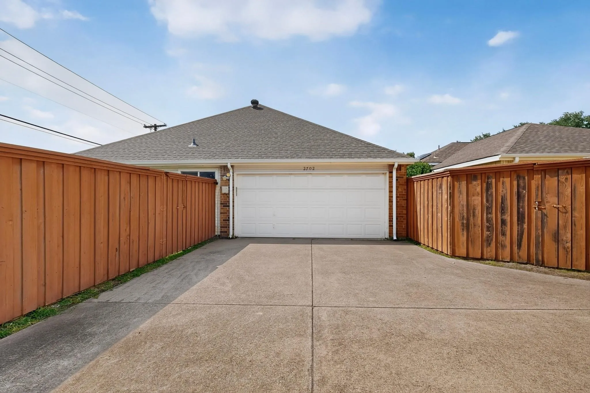 Attached two-car garage with a concrete driveway and brick exterior detailing