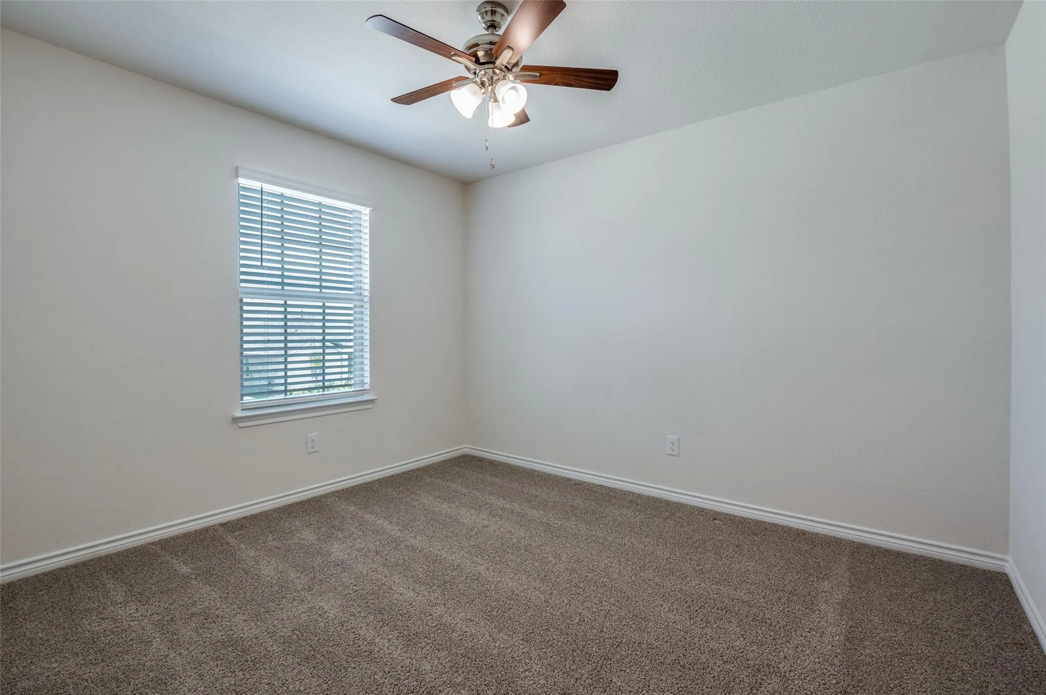 Neutral wall finishes, recessed window, window blinds, ceiling fan, and carpet flooring