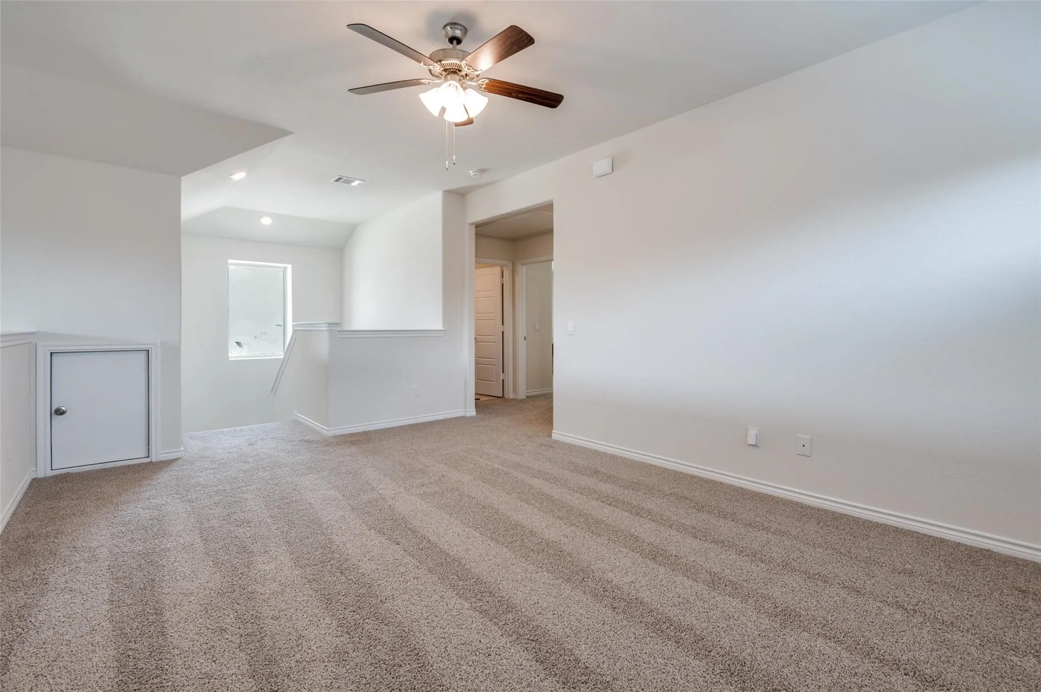 Carpeted flooring, ceiling fan, recessed lighting, white painted walls, and a window