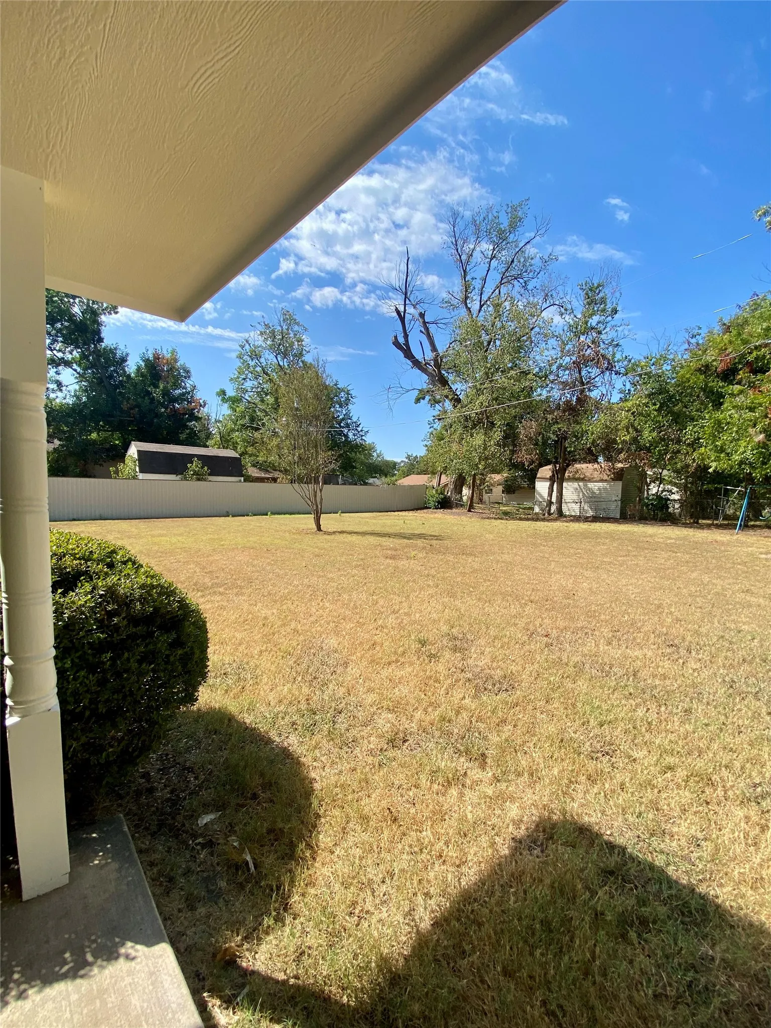 Backporch looking SW Expansive exterior space featuring a large lawn area, mature trees, and privacy fencing