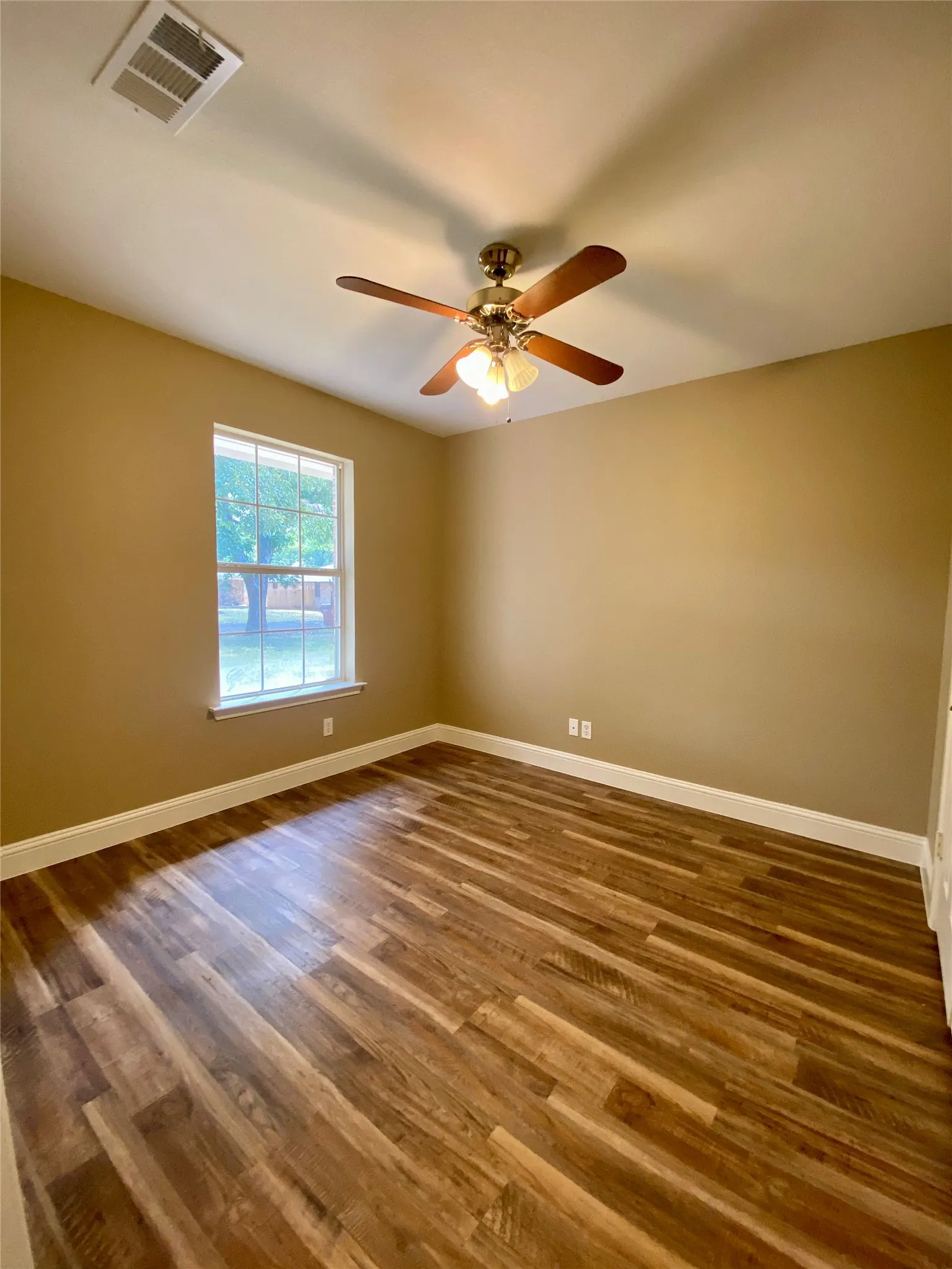 Bedroom #3 Wood-finish flooring, single window, ceiling fan with integrated lighting, and neutral wall tones