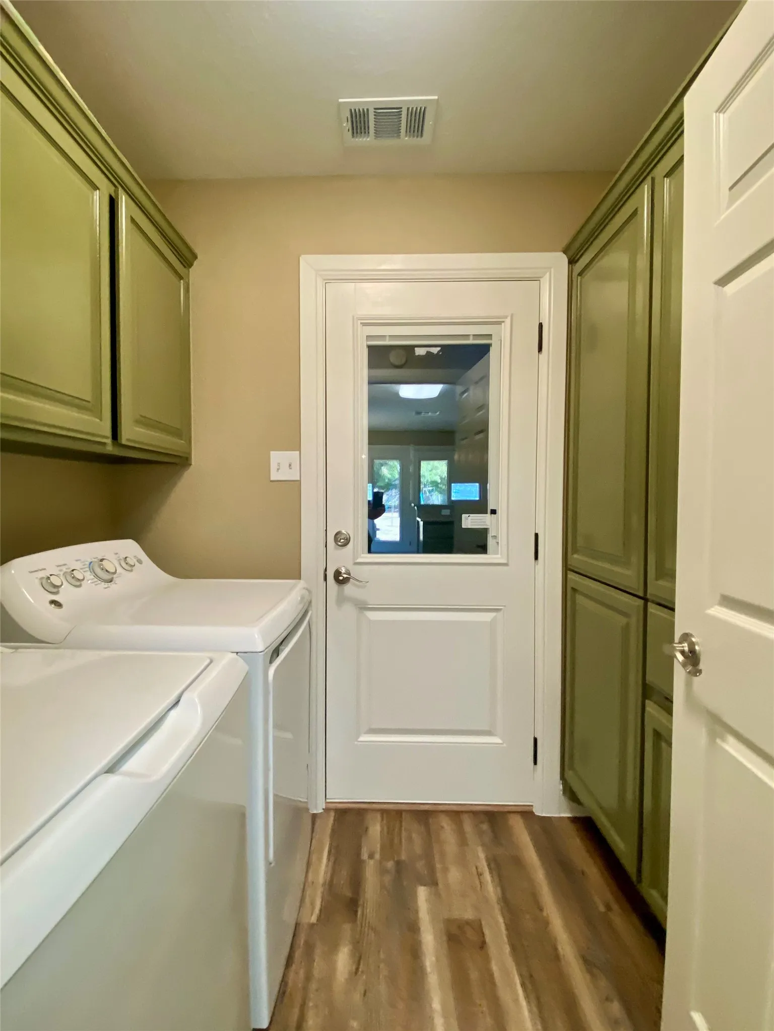 Laundry going into garage Wood-finish flooring with full-height cabinetry