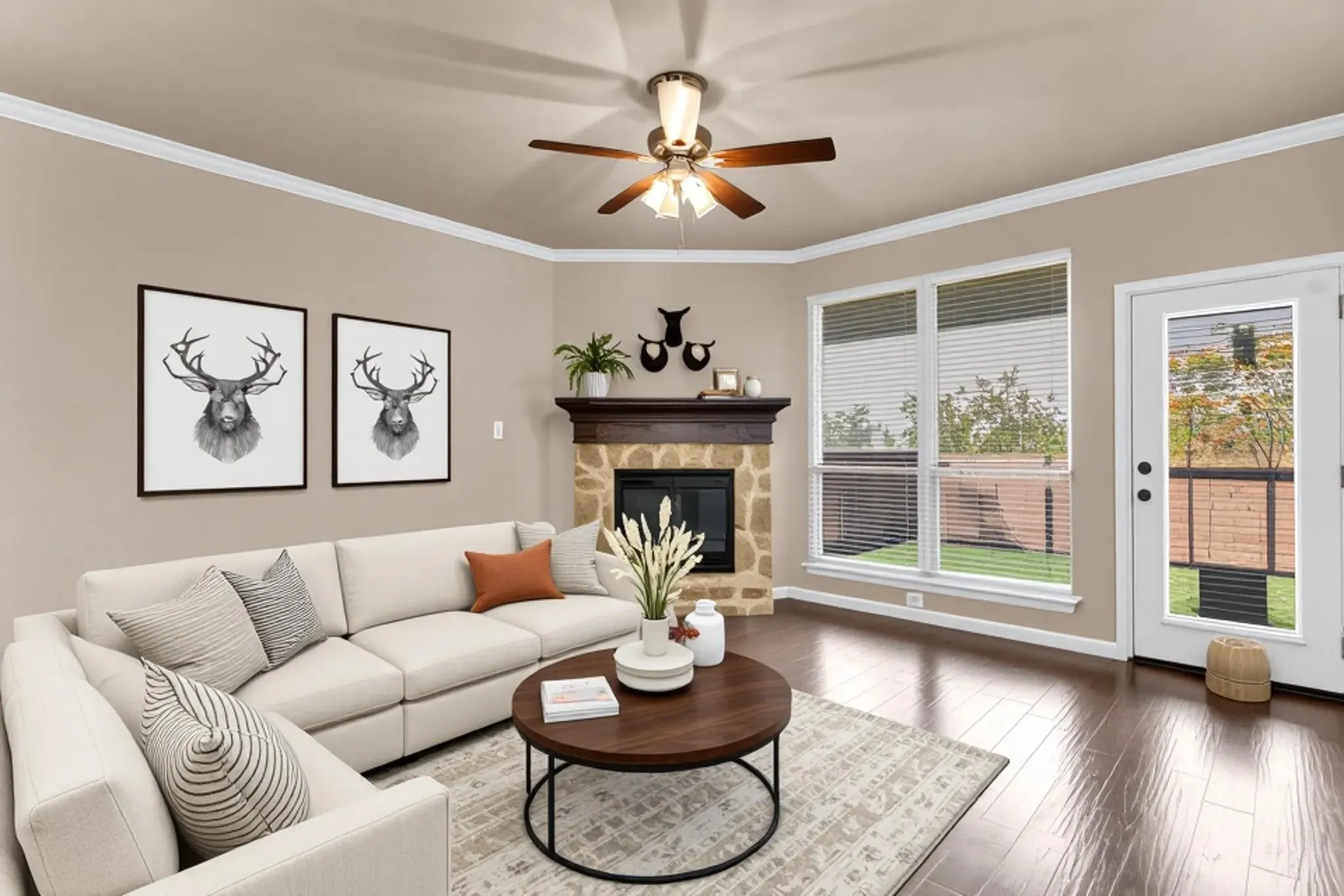 Hardwood flooring, crown molding, a ceiling fan, a stone fireplace with a wood mantle, and a glass-paneled door