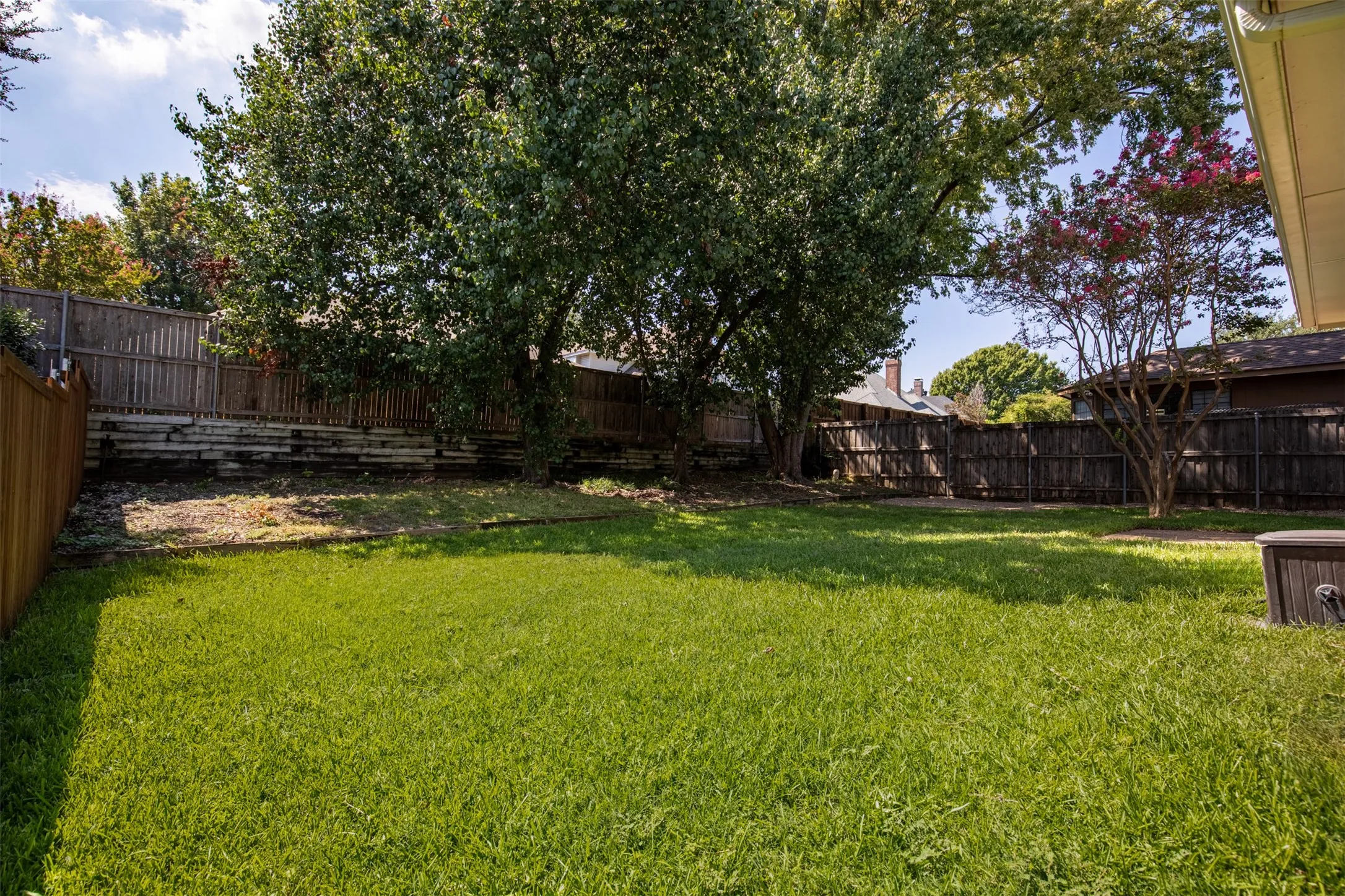 Grassy back yard with privacy fencing.
