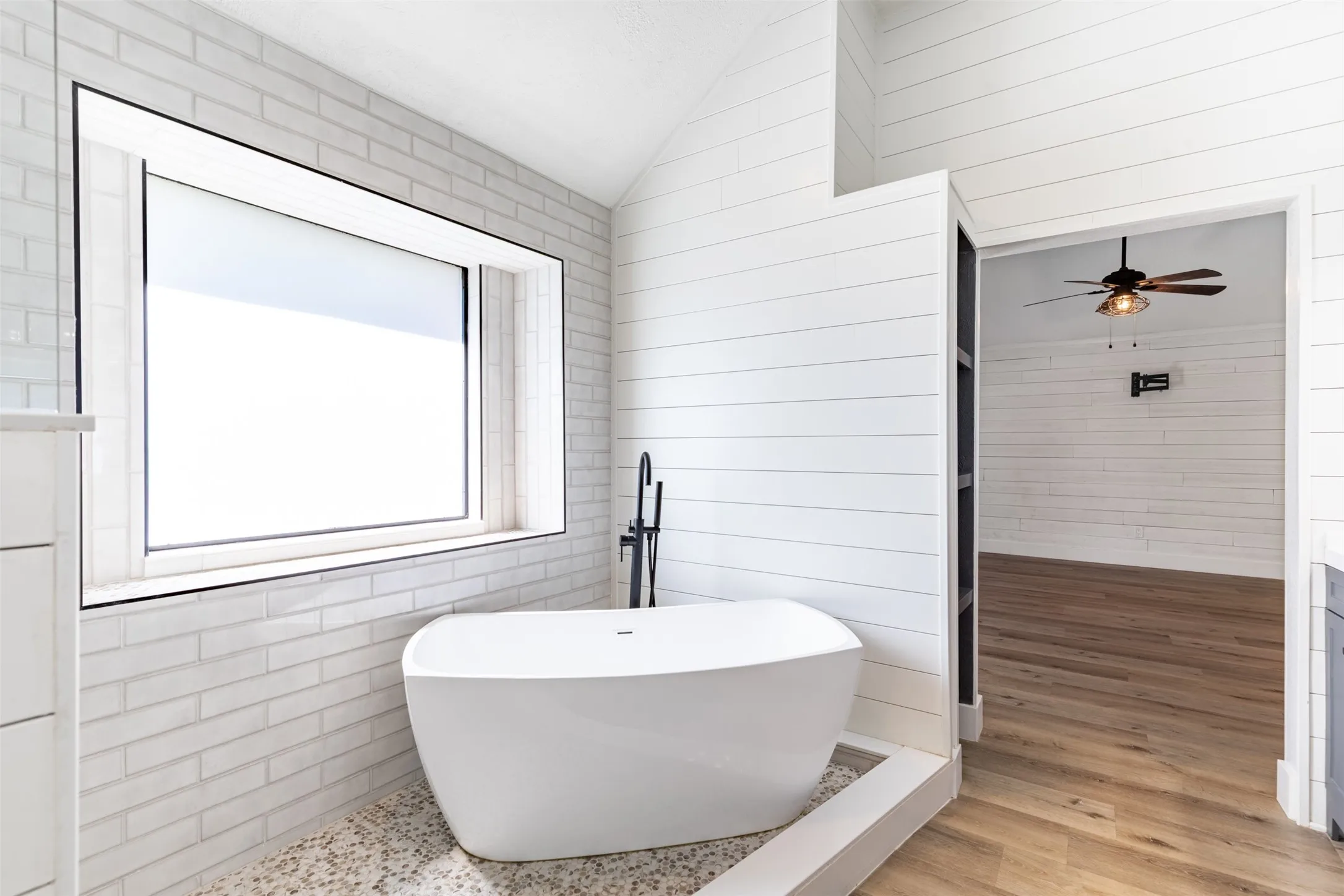 En-suite bath features soaking tub and natural light.